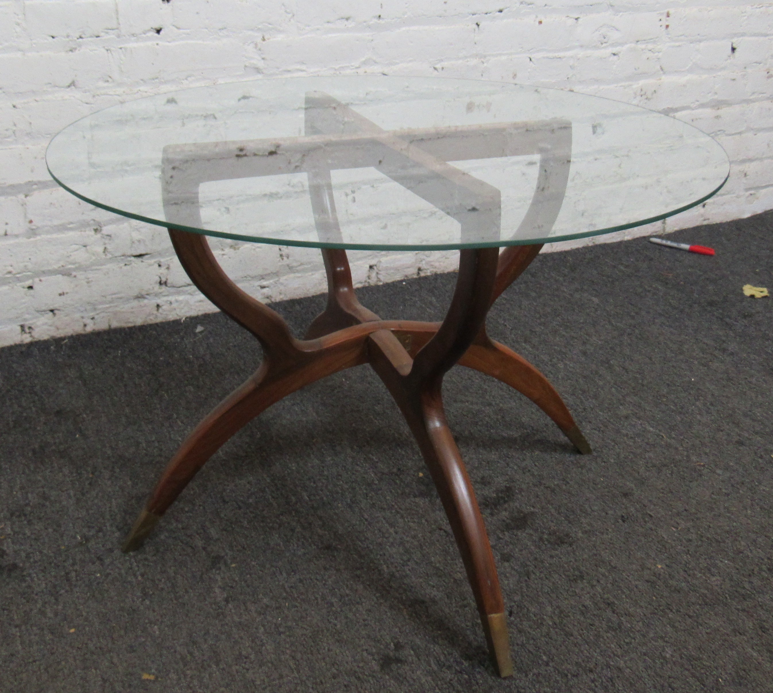 Unique glass top coffee or side table with an elegant wooden base. The base folds in half. 
Location: Brooklyn NY.