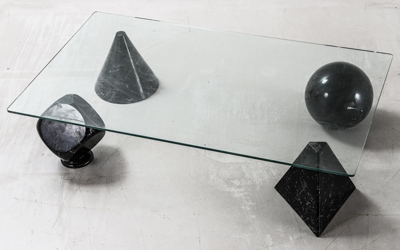  Coffee table from the late 1970s, made up of a glass table top and black with white veins marble effect sculptural bases. Four sculptural bases: a cube, a cone, a sphere and a pyramid. The four shapes are not fixed and can be repositioned freely,