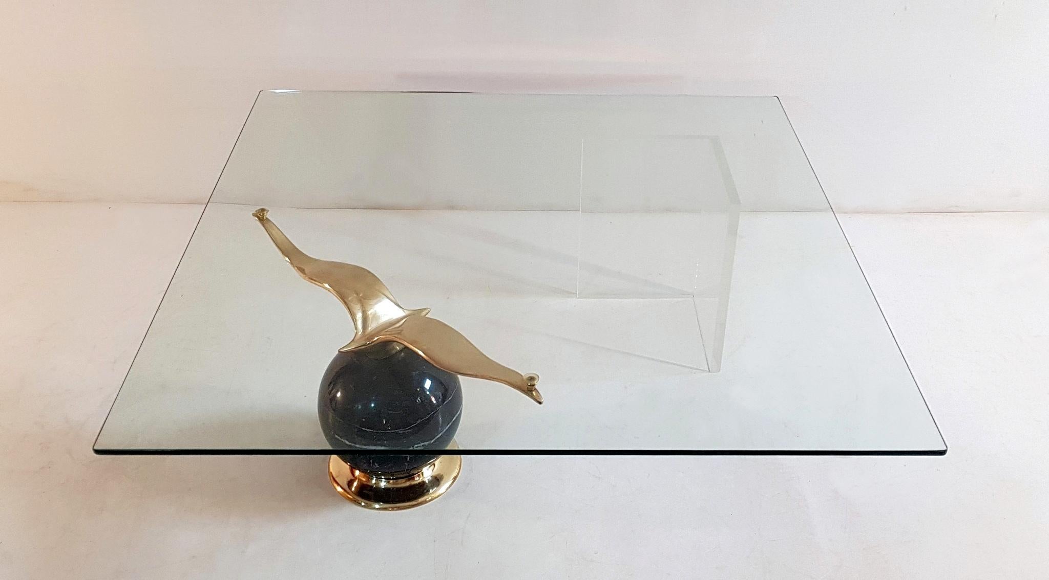 Spectacular square glass coffee table resting on a large bronze seagull sitting on a large ball in Madagaskar marble. On the other side there is a corner made of Lucite which makes it look as though the top is resting only on one side almost.