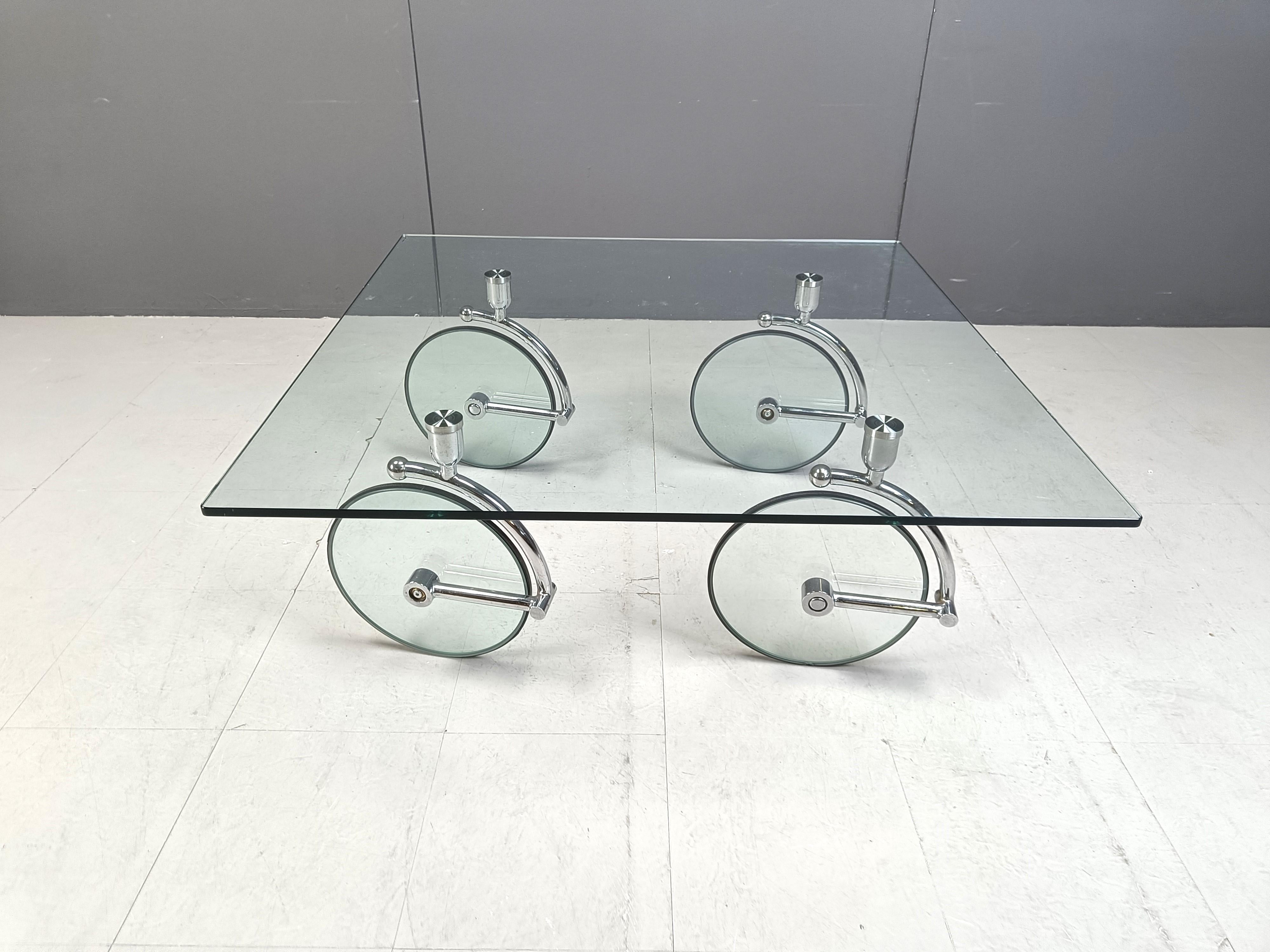 Timeless coffee table in the manner of Gae Aulenti for Fontana arte. Often wrongly sold as being a design of hers.

Made out of a thick clear glass top, chrome sculpted legs to hold the clear glass wheels which support the table.

Thanks to those