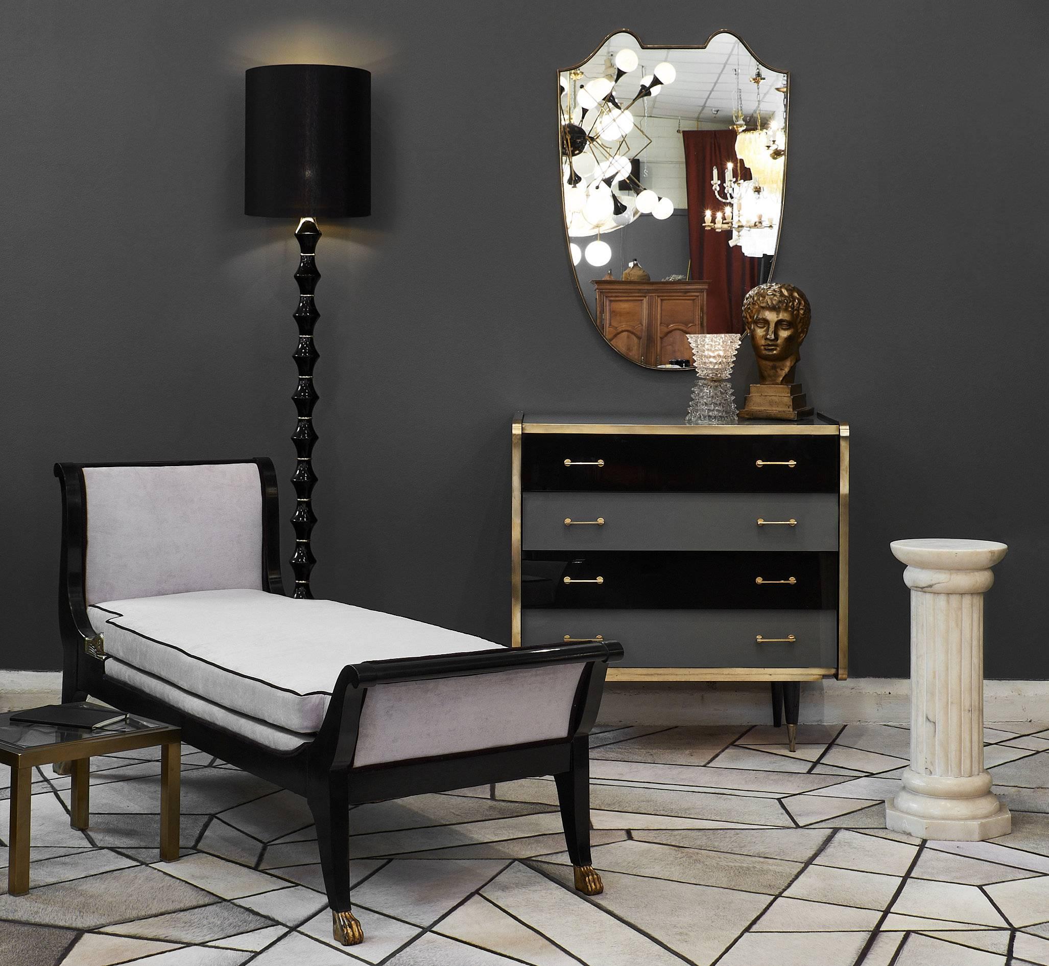 A refined Italian vintage glass covered chest of drawers in two tones of glass, black and gray. The piece has four drawers, with brass trims and handles. We loved the impeccable details such as the tapered legs, and the glass and brass combination.