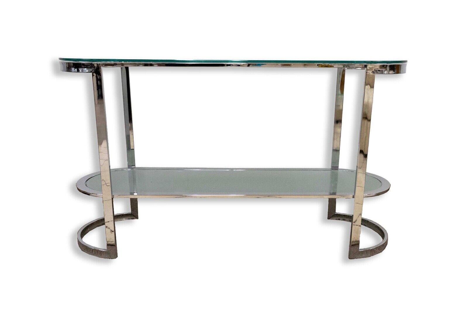 Notre table console en verre et chrome incurvé est un mélange étonnant de forme et de fonction. Cette pièce moderne contemporaine incarne l'élégance élégante et le design audacieux, ce qui en fait un ajout frappant à tout espace de vie. Artistics