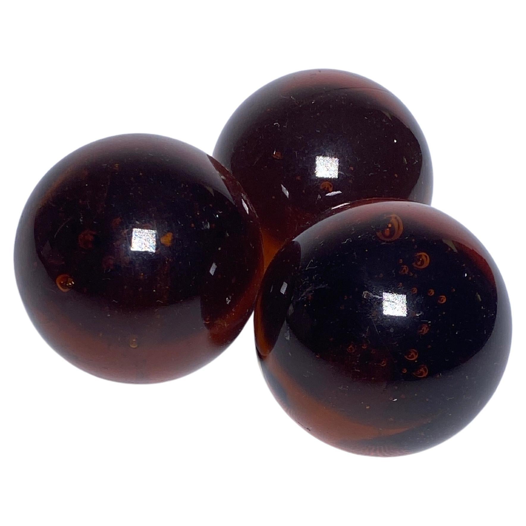This is a decorative set of 3 balls, in glass. It is in a brown color. It has been made in france circa 1970.