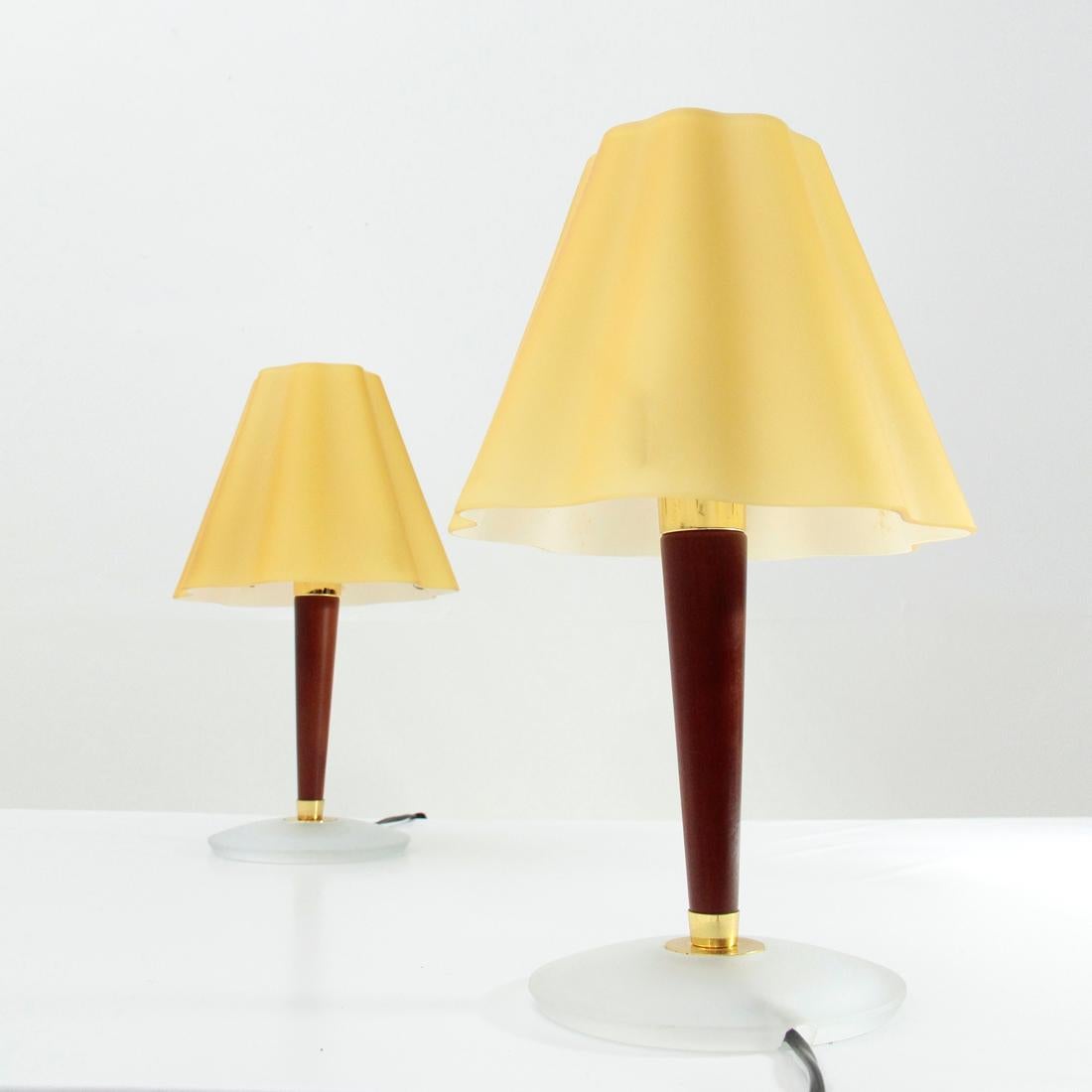 Pair of table or bedside lamps produced by Fabbian in the 1990s. 
Base in frosted glass, stem in wood and brass-plated metal.
Diffusers in cased glass. 
Good general conditions, some signs due to normal use over time,
lack of paint on the