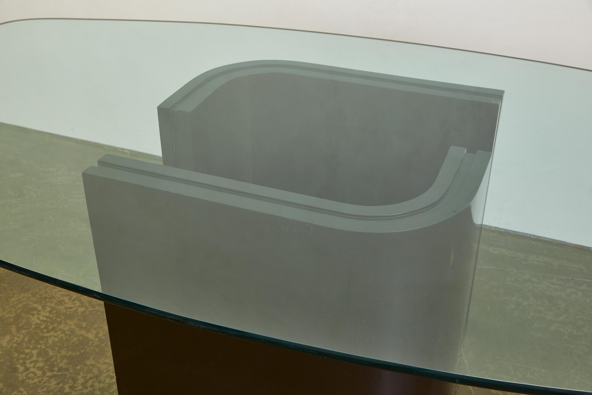 This Modern glass dining table, attributed to Argentinian designer Alberto Churba, exemplifies his innovative approach to South American Modernism. Crafted in 1965, the table features a dark brown lacquered base composed of two curved sections with
