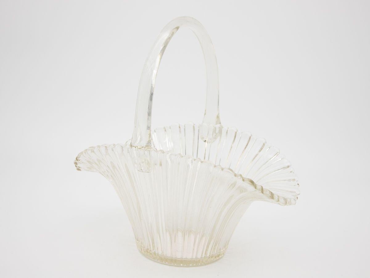 A molded glass candy dish in the shape of a basket. Wear consistent with age and use.