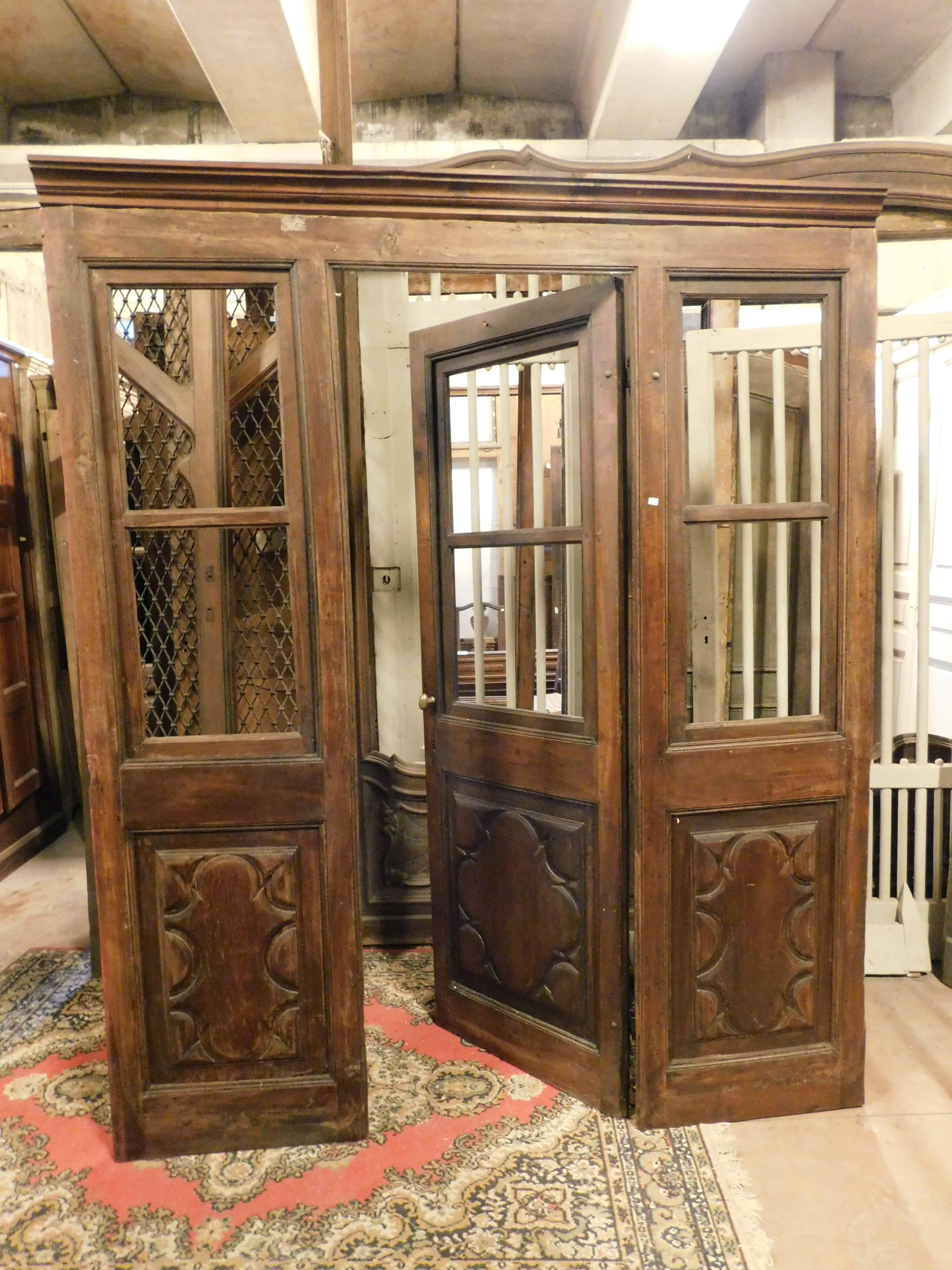 Ancient shop door, entrance door with showcase, entirely hand-carved with panels in precious solid walnut wood, complete with central door, side windows and complete frame, with push opening to the right and opening doors, still retains the original