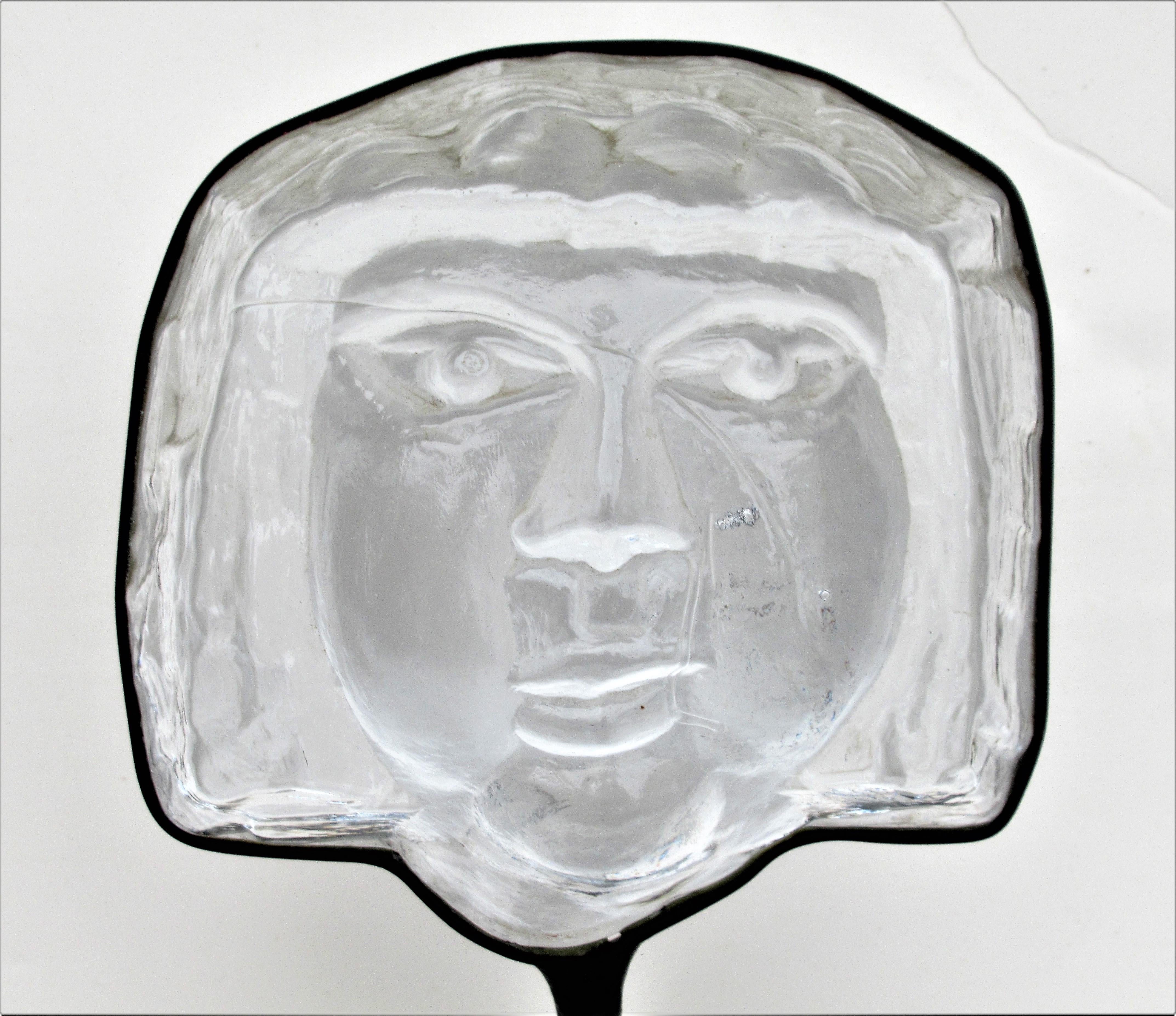Glass face sculpture mounted in original black enameled iron frame with Stand by Erik Hoglund for Kosta Boda – Sweden, circa 1960. Marked Boda on underside of circular iron base.