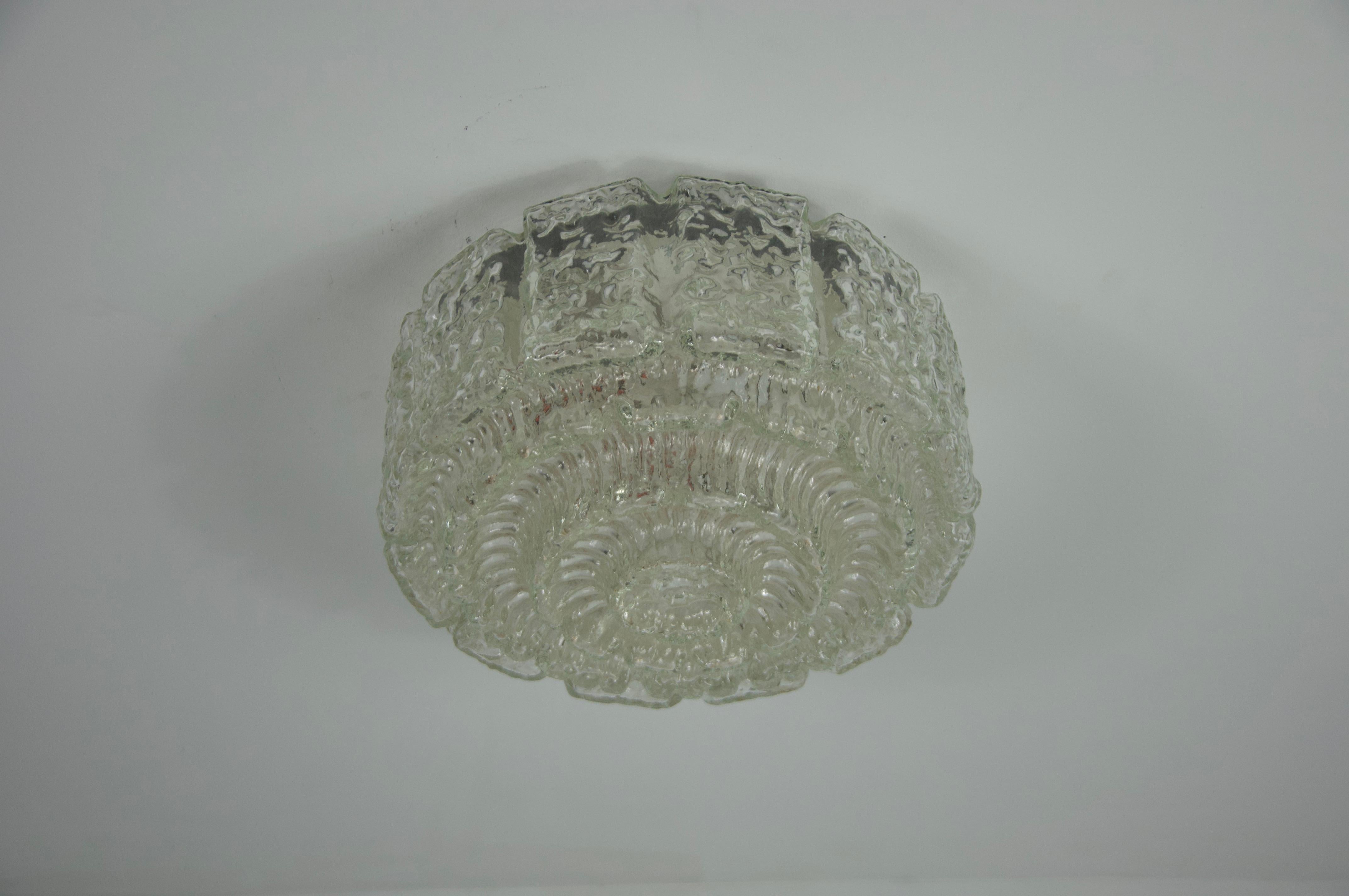 This elegant flush mount ceiling light was produced by the renowned German manufacturer Glashütte Limburg in the 1960s. Featuring a beautifully textured glass shade with intricate, ice-like detailing, this piece exemplifies the craftsmanship and
