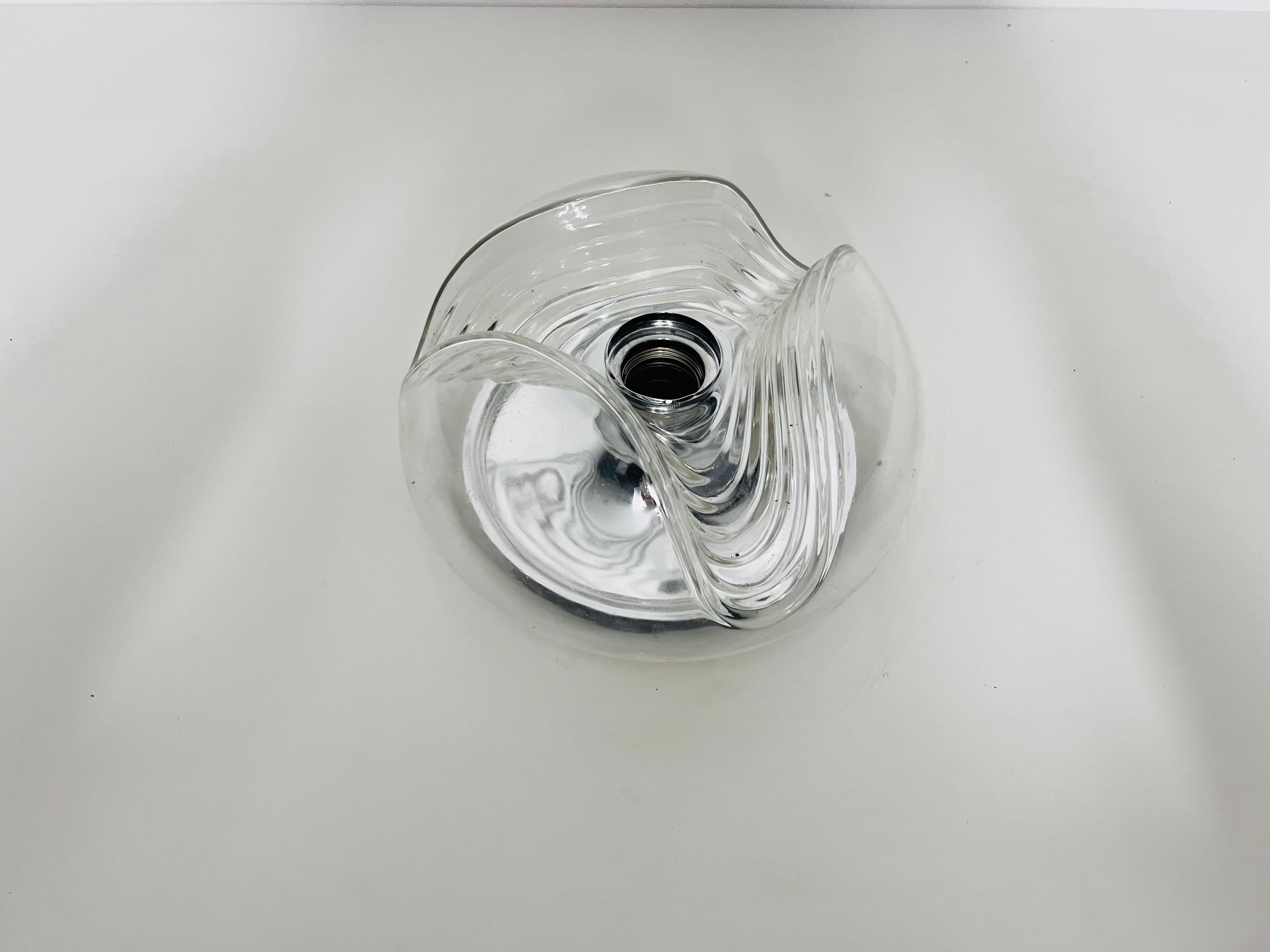Cet encastré rond de Koch & Lowy pour Peill et Putzler, fabriqué en Allemagne dans les années 1960, séduit par la beauté de son verre. La lampe incarne le design caractéristique de l'ère spatiale, caractérisé par des formes futuristes et des lignes