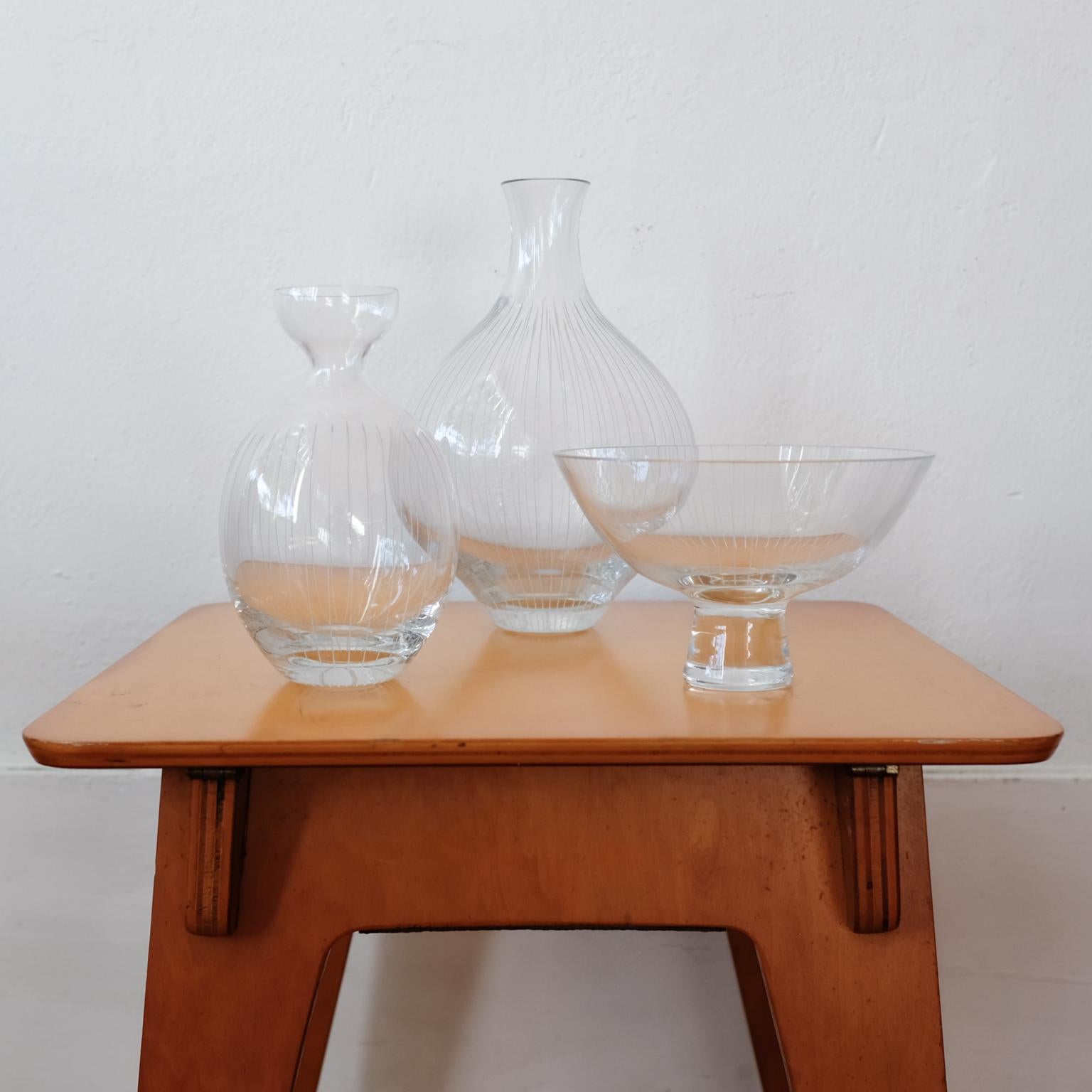 A set of three incised glass pieces by Harrison McIntosh (11 September 1914 -21 January 2016). Mostly known for ceramics, these glass pieces were designed after three of his most well-known forms and lined decoration. The bottle and compote forms