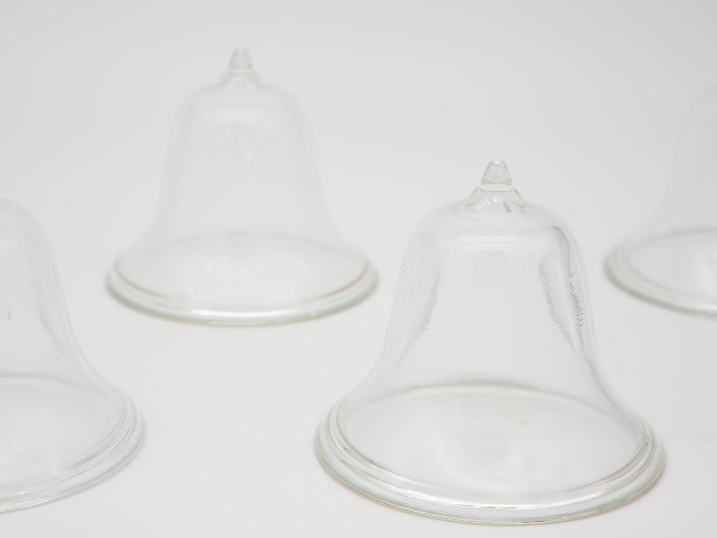 A set of four mini glass cloches. Ideal table top or bookshelf size. French midcentury. Wear consistent with age and use.