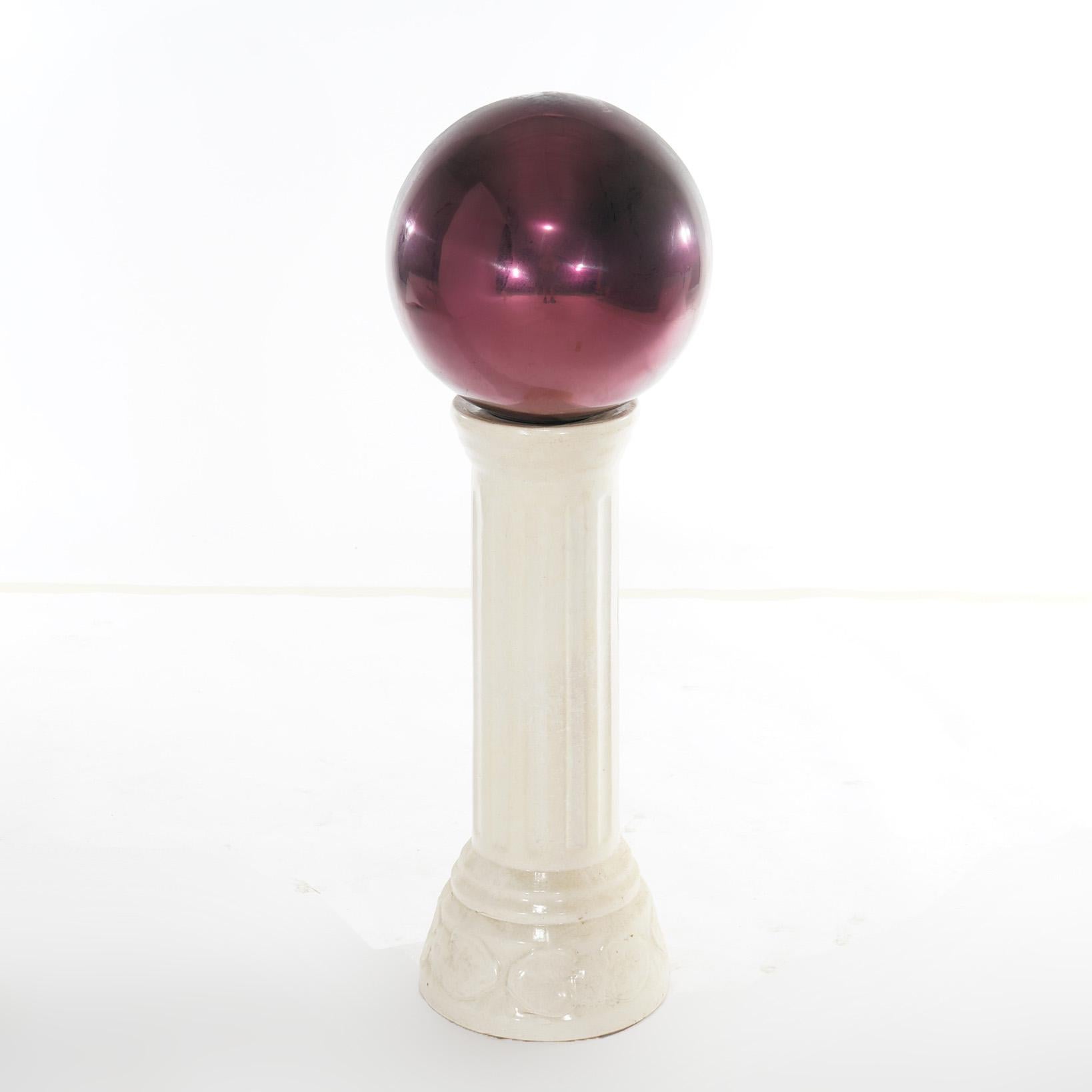 A garden gazing ball offers glass globe on pottery pedestal, 20th century

Measures - 35