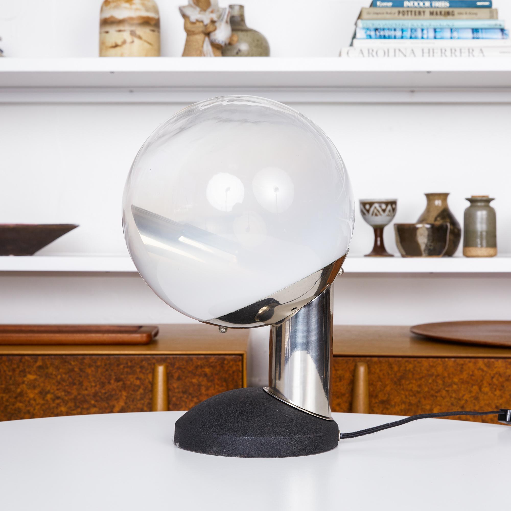 Glass globe table lamp by Kosta, Sweden, circa 1960s. The Space Age style lamp features a frosted translucent glass globe supported by an articulating chrome stem that sits on a blackened steel base. The interior of the globe houses a chrome-plated