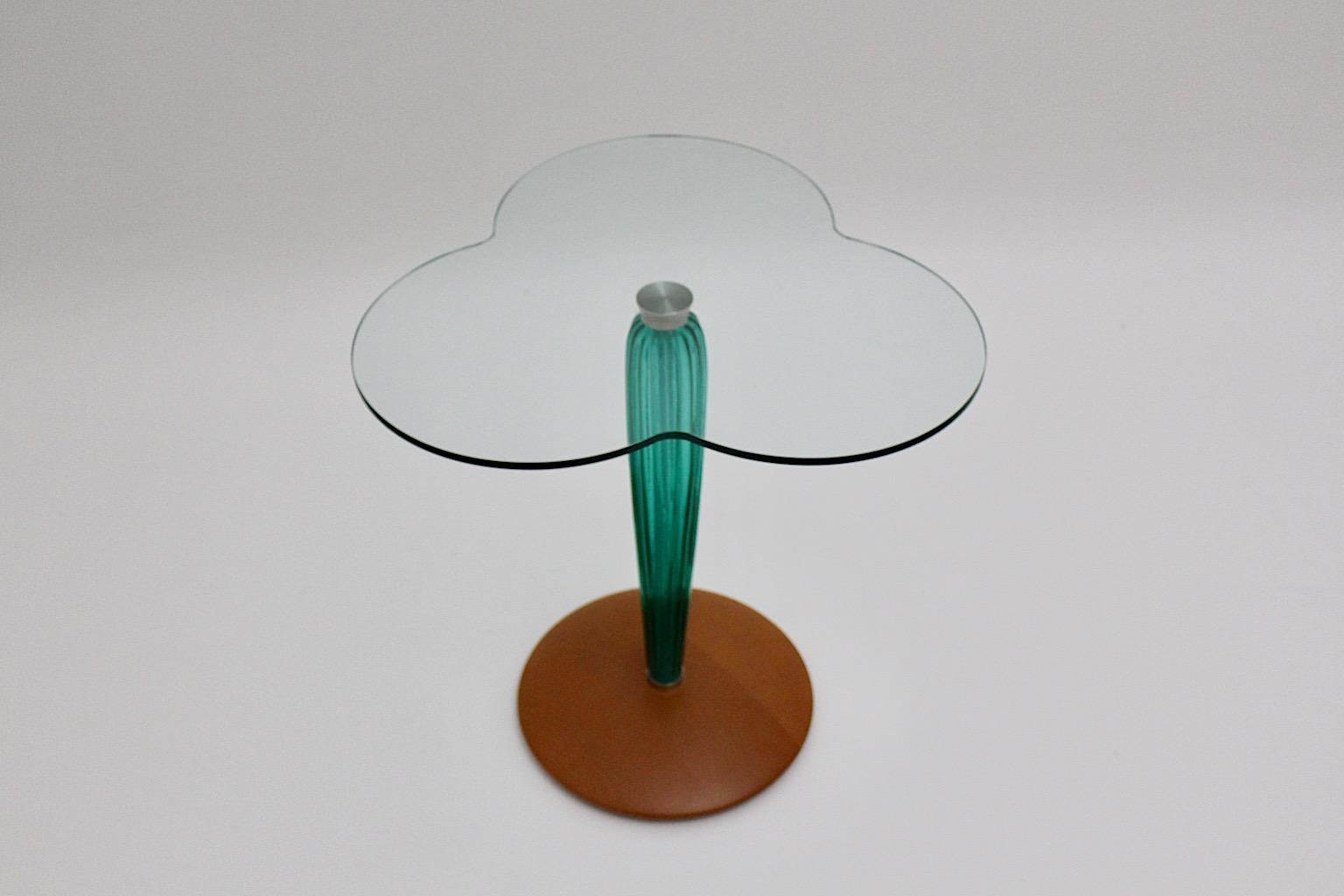 Beistelltisch aus grünem und klarem Glas, Seguso zugeschrieben, entworfen und ausgeführt in Italien um 1980.
Ein toller Beistelltisch aus Klarglas, Grünglas und Buche in einer schönen Kleeblattform. Der runde, scheibenförmige Fuß aus Buche zeigt