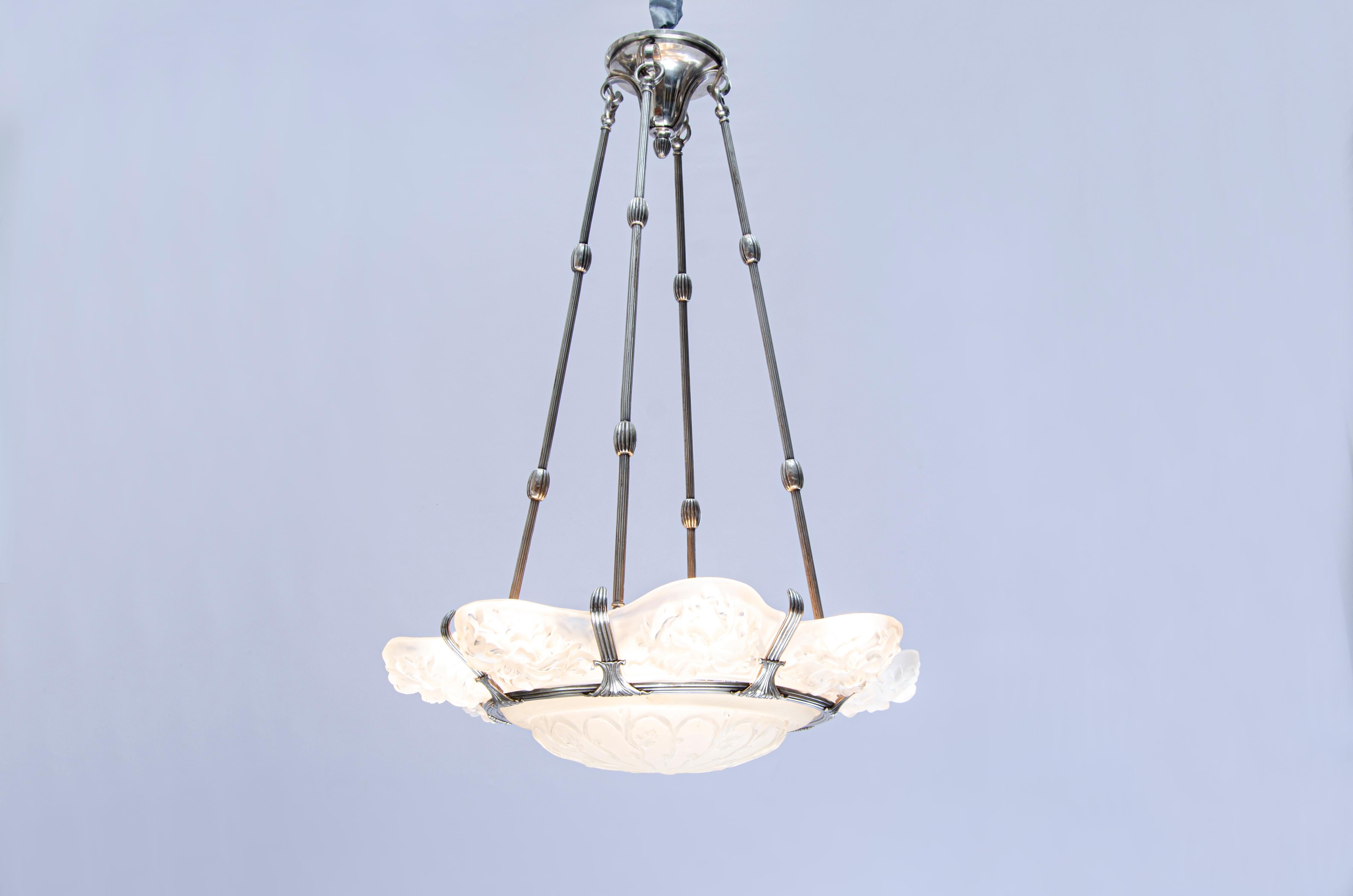 Lampada a sospensione in vetro di Marius-Ernest Sabino (1878-1961). Struttura in bronzo argentato con 9 paralumi in vetro, compreso quello centrale.

Francia, CIRCA 1920.