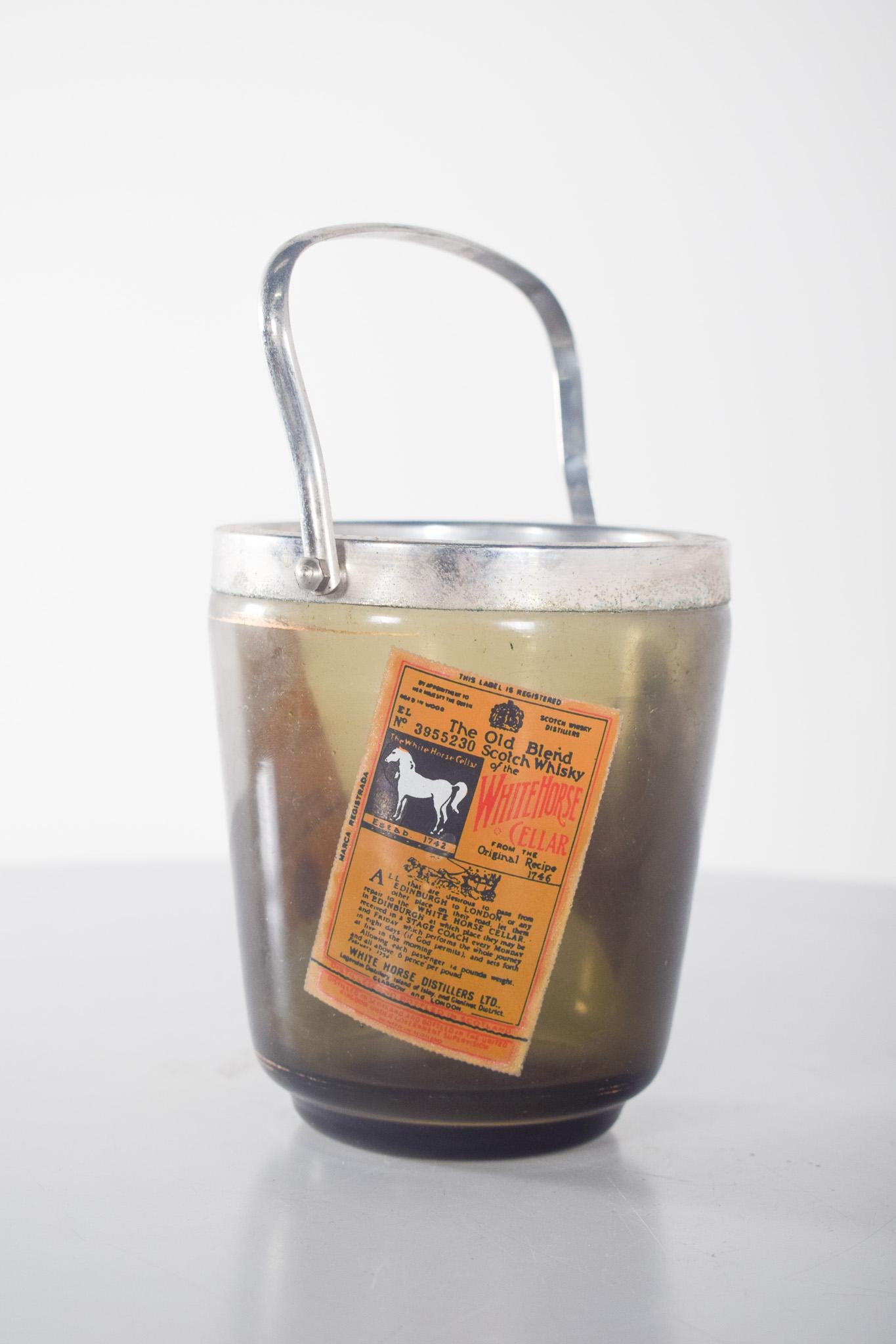 Seau à glace en verre.
Seau à glace en verre. Marqué Ballantine's et Bell's, il s'agit d'une pièce de collection, idéale pour les amateurs de whisky et d'objets publicitaires vintage. Fabriquée en verre épais, elle présente une couleur ambrée foncée