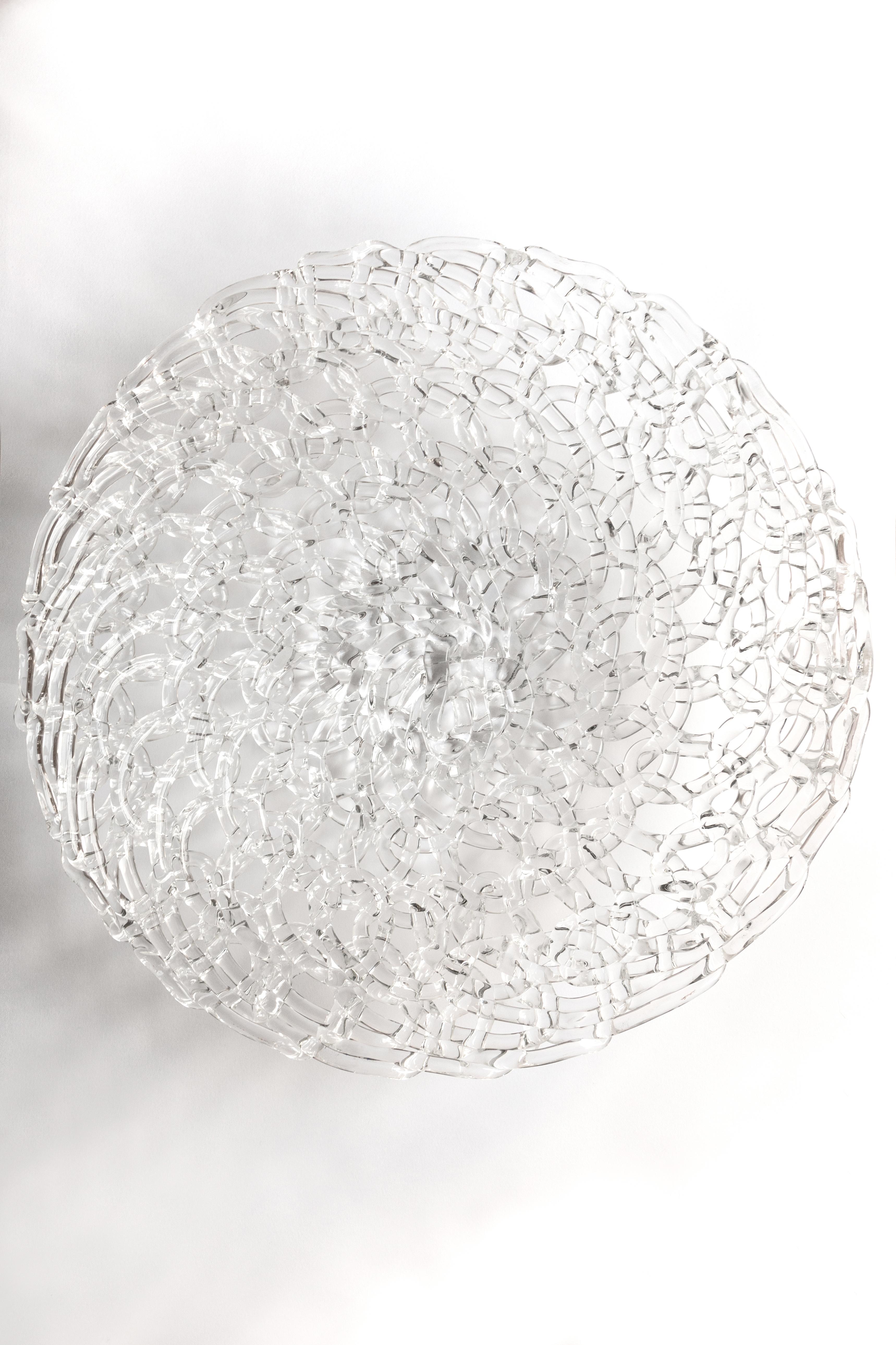 Is a centerpiece,
Is a fruit holder,

Is a single piece of glass,
cast, hand embroidered,

It's an invention, it's a sculpture,
takes the light and breaks it into a thousand pieces,
it is an object that furnishes captivating the eyes.