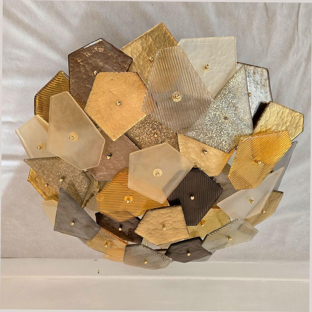 Large Modern Murano glass flush mount chandelier, Italy 21st century.
The Italian flush mount light is made of various shapes, colors and finishes pieces of glass from an old Mazzega stock, 1980s.
The colors are warm: from translucent to brown, with