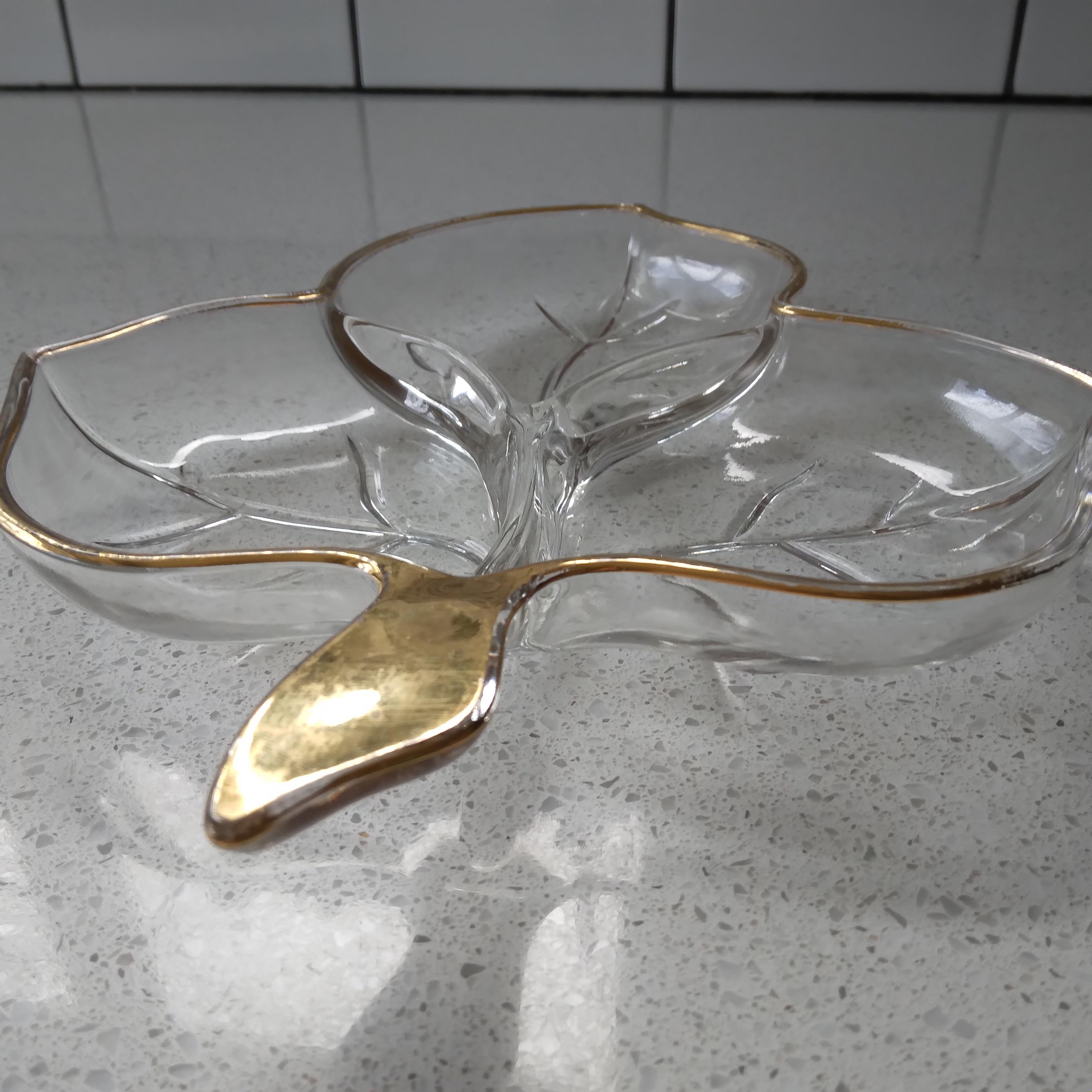 Natural leaf shape in a clear glass medium. We love the gold rimmed edge and stem. The three separate sections are decorated with a delicate vein in clear glass. This vintage piece would be a great addition to your dinnerware collection!

Minor