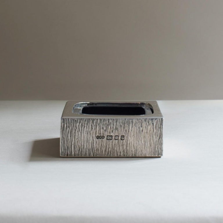 A fantastic rectangular smokers cigarette or cigar ashtray modelled in 'wood grain' textured silver with a removable glass liner. By influential mid-century silversmith Gerald Benney, hallmarked London 1972. Originally made as a centenary