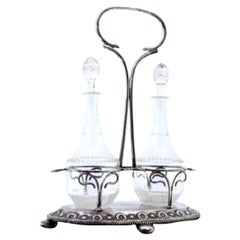 Glass liqueur/cruet set with two cut glass cruets on a silver frame