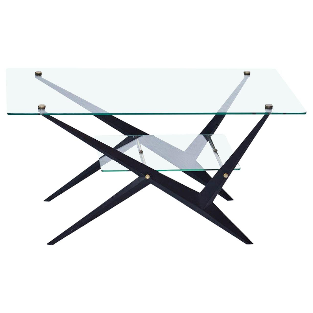 Coffee table designed by Angelo Ostuni. 
Manufactured in Italy during the 1950s. 
Glass top and lower tray, brass and black lacquered metal frame / legs.