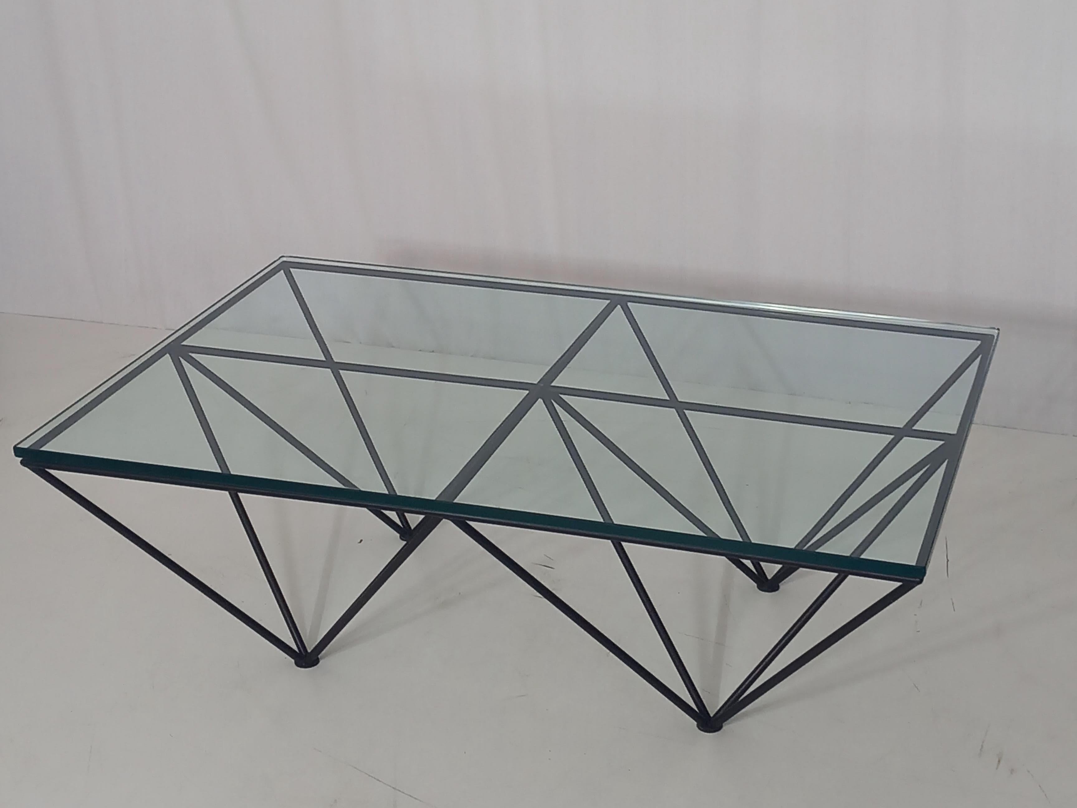A striking coffee table from the 1980s, this piece blends glass and metal in a bold, geometric design. Its clean lines and peculiar shape - reminiscent of diamonds or upside-down pyramids - give it a sculptural presence that stands out without