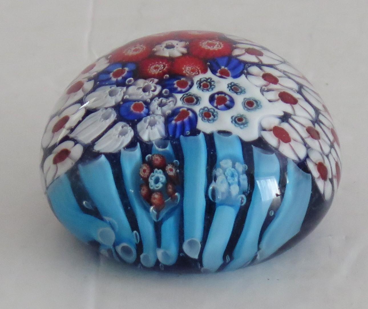 This is a beautiful handmade Millefiori collectors Paperweight,  that we attribute to a Scottish maker, Circa 1970.

This paperweight is handmade with a mixed Millefiori cane design, the canes arranged to represent a flower basket with the light