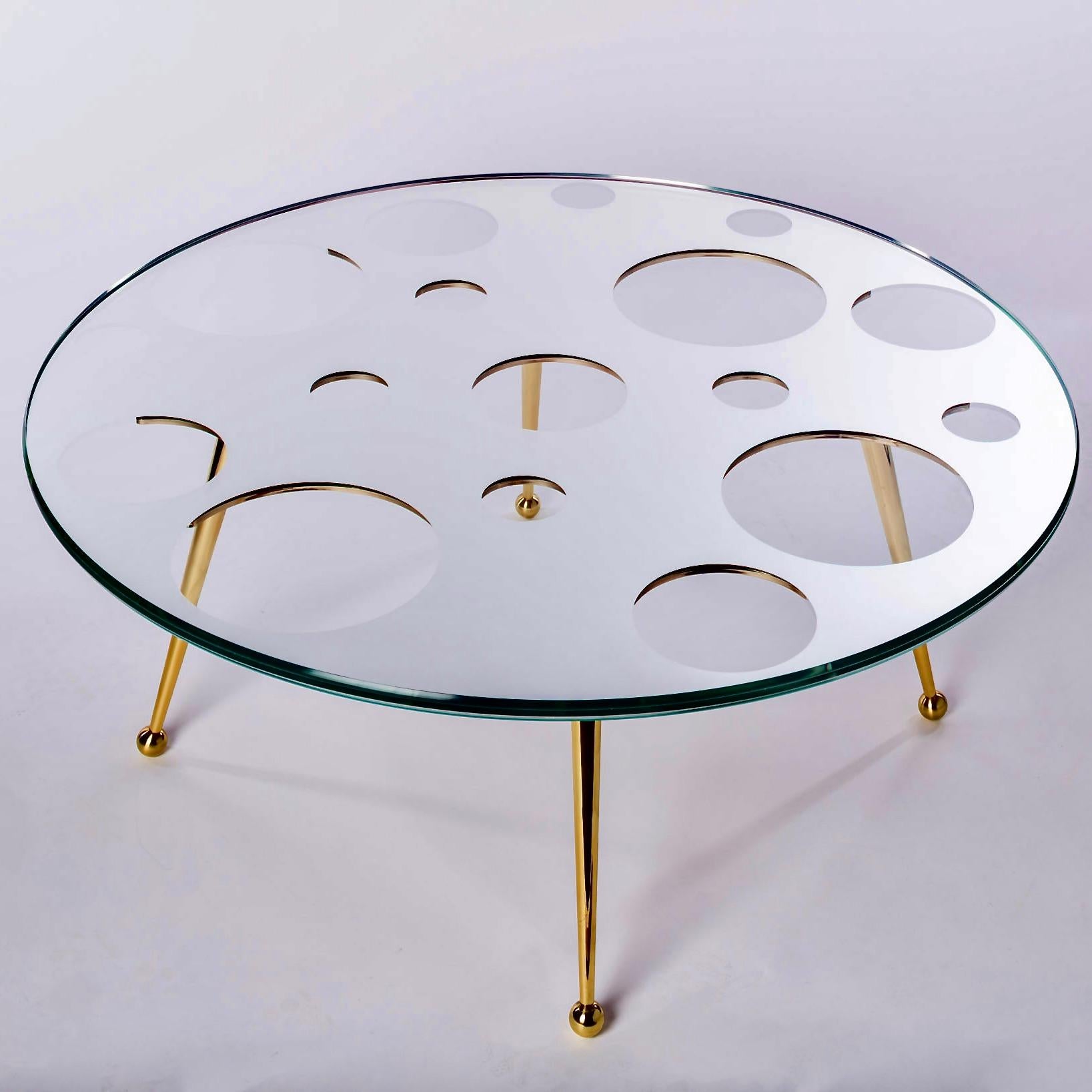 The Holy Mirror Coffee Table is made from solid brass legs and has a very unusual handmade mirror glass top. 

The top is made by taking three equal pieces of Starphire glass, the middle section is taken to a printer that digitally prints a mirror