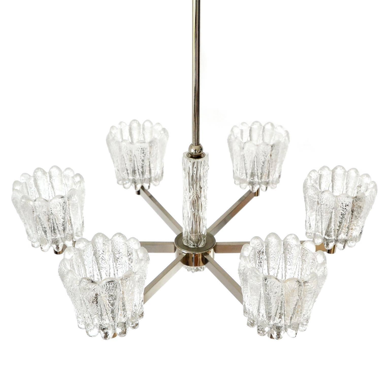 A beautiful and high quality chandelier by Carl Fagerlund for Orrefors, Sweden, manufactured in midcentury, circa 1960.
The lamp is made of a nickeled or chromed brass frame and frosted textured ice glass lamp shades.
The fixture has six arms with