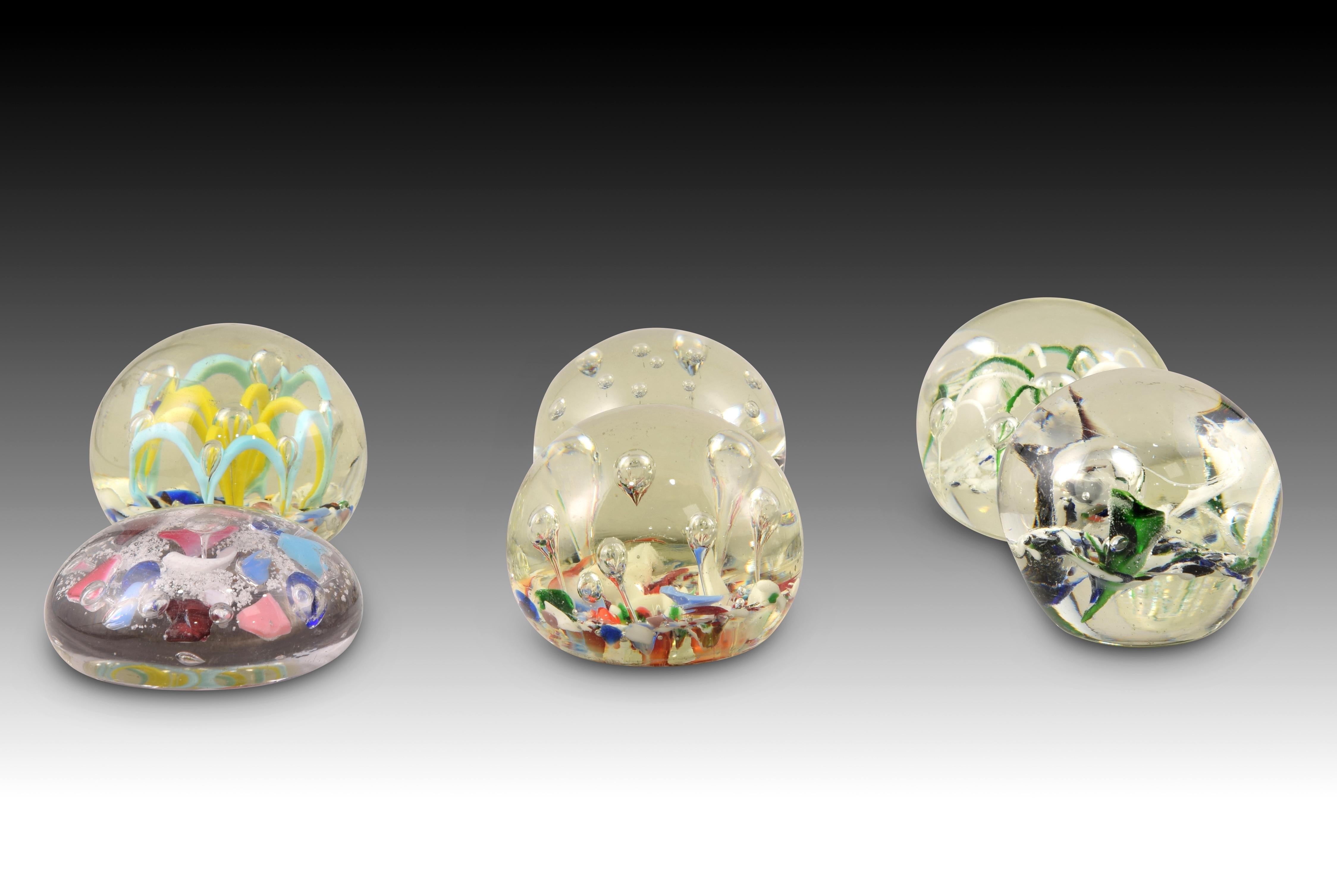 Paperweight. Glass. 
 Paperweight made of glass combining transparent with various colors. Several models are available, and price per unit is indicated. 
Set weight: 3 kg. Price per unit· Size: 7,5x7,5x3,5 / 7,5x7,5x6 cms.