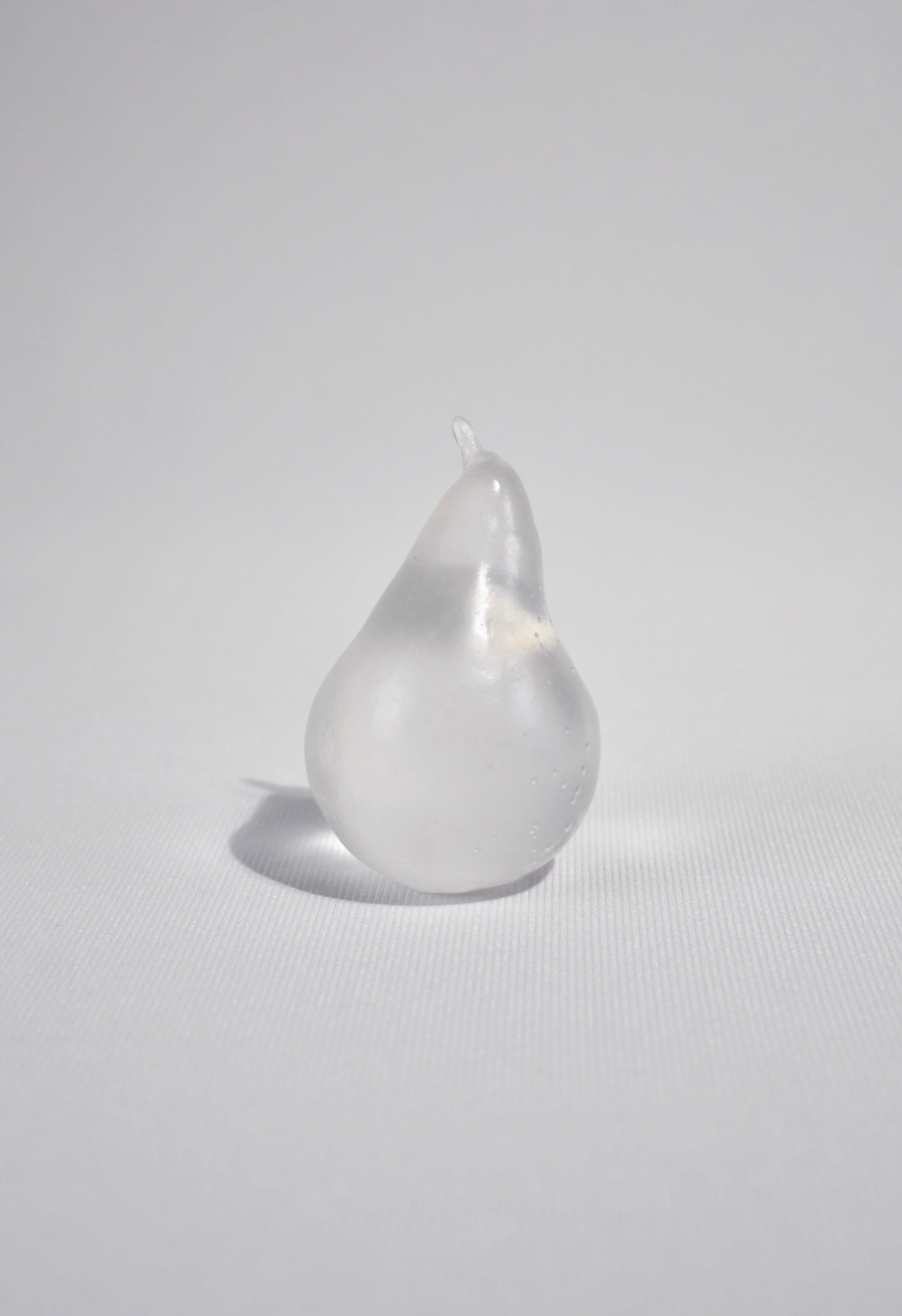 Casted glass pear in clear by Devon Made Glass Fruit inspired by blown glass fruit makers and collectors from the 1960's. The light playful approach to everyday fruit is contrasted with the heaviness of the crystal glass, a unique material that