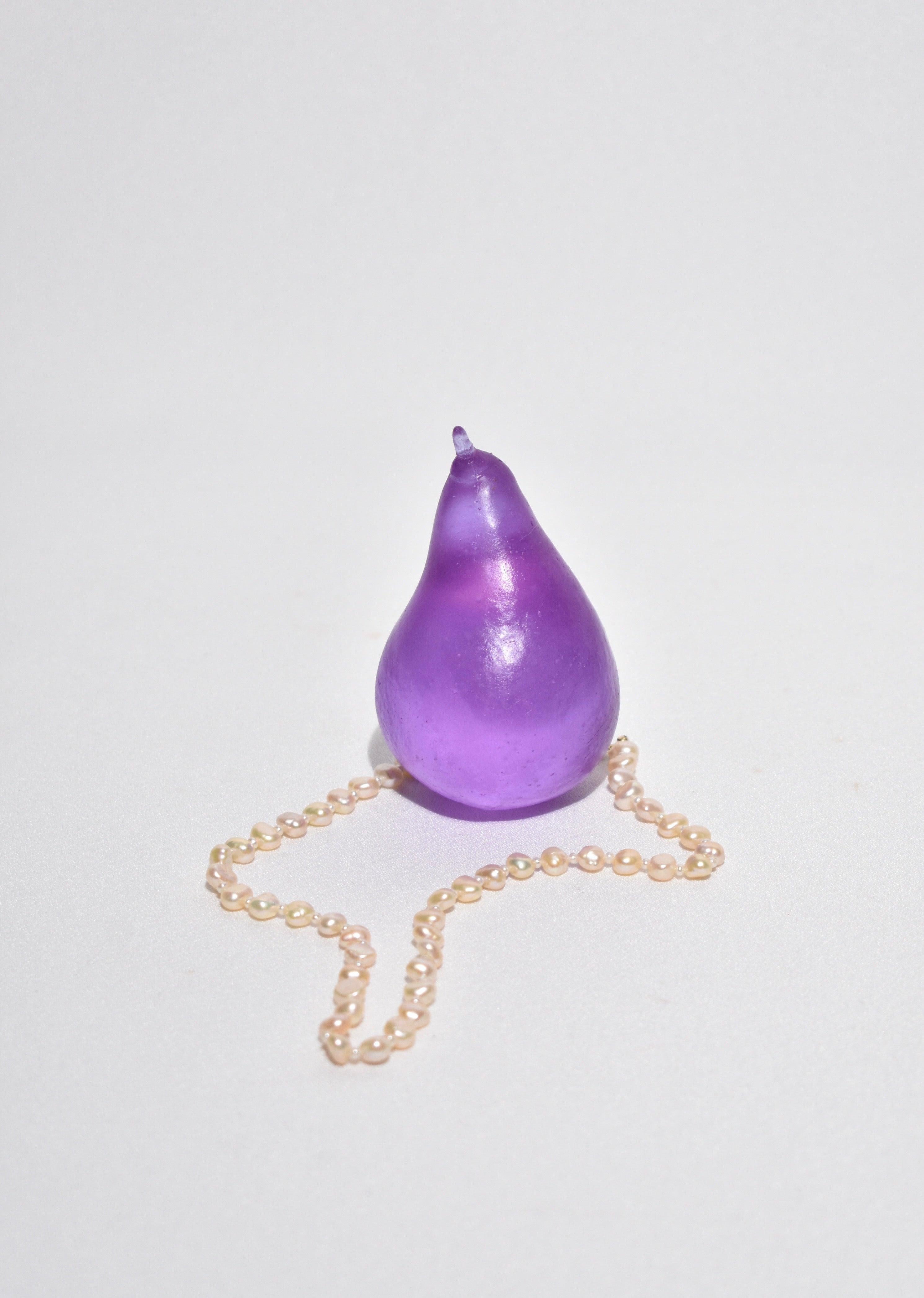 Casted glass pear in dichroic lilac by Devon Made inspired by blown glass fruit makers and collectors from the 1960's. The light playful approach to everyday fruit is contrasted with the heaviness of the crystal glass, a unique material that catches