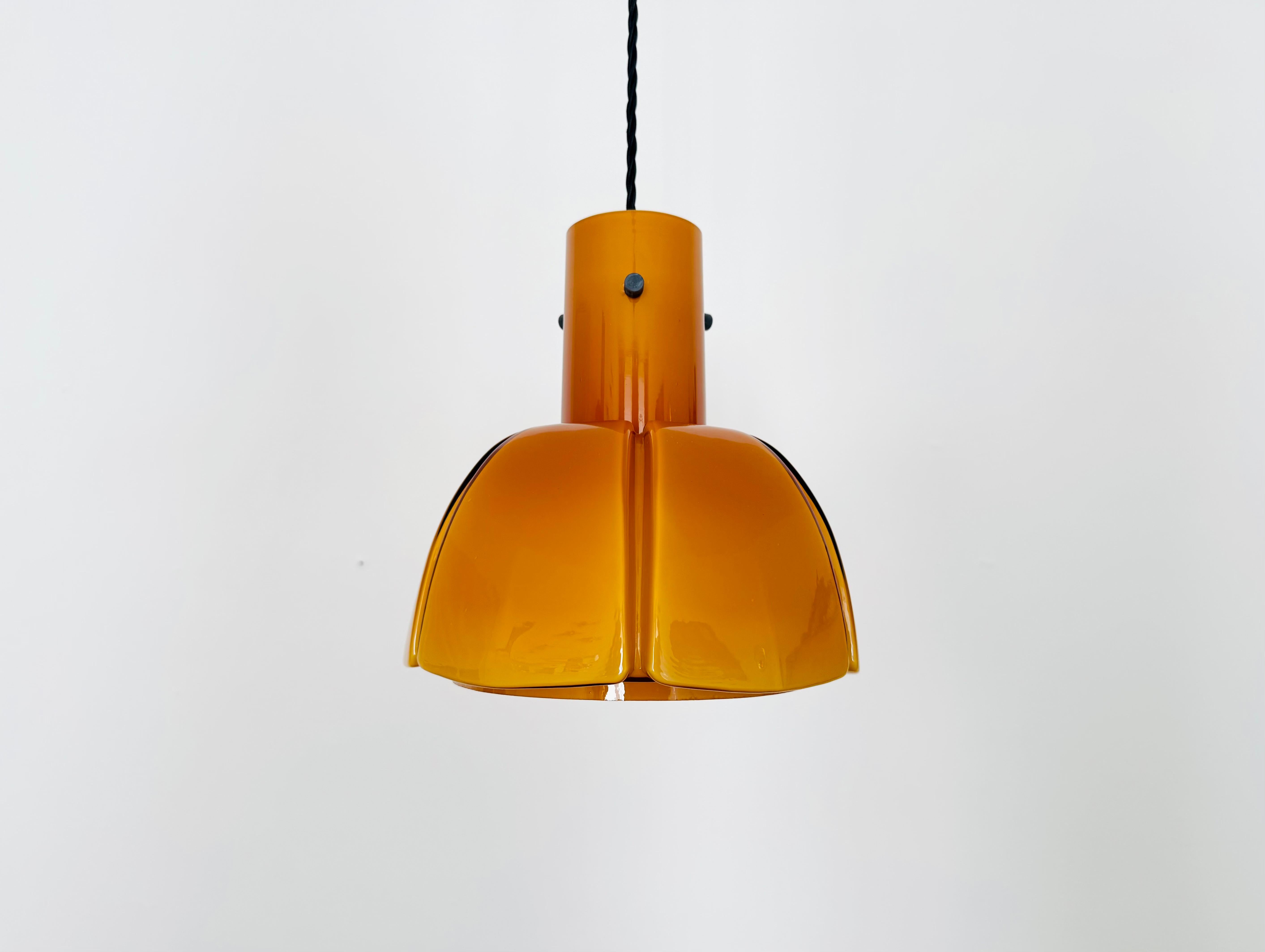 Lampada a sospensione molto bella e rara degli anni '60.
Il vetro soffiato a mano in una tonalità ambrata è un vero e proprio richiamo per gli occhi e ha un design impressionante.
La lampada crea un'atmosfera accogliente e incanta con il suo