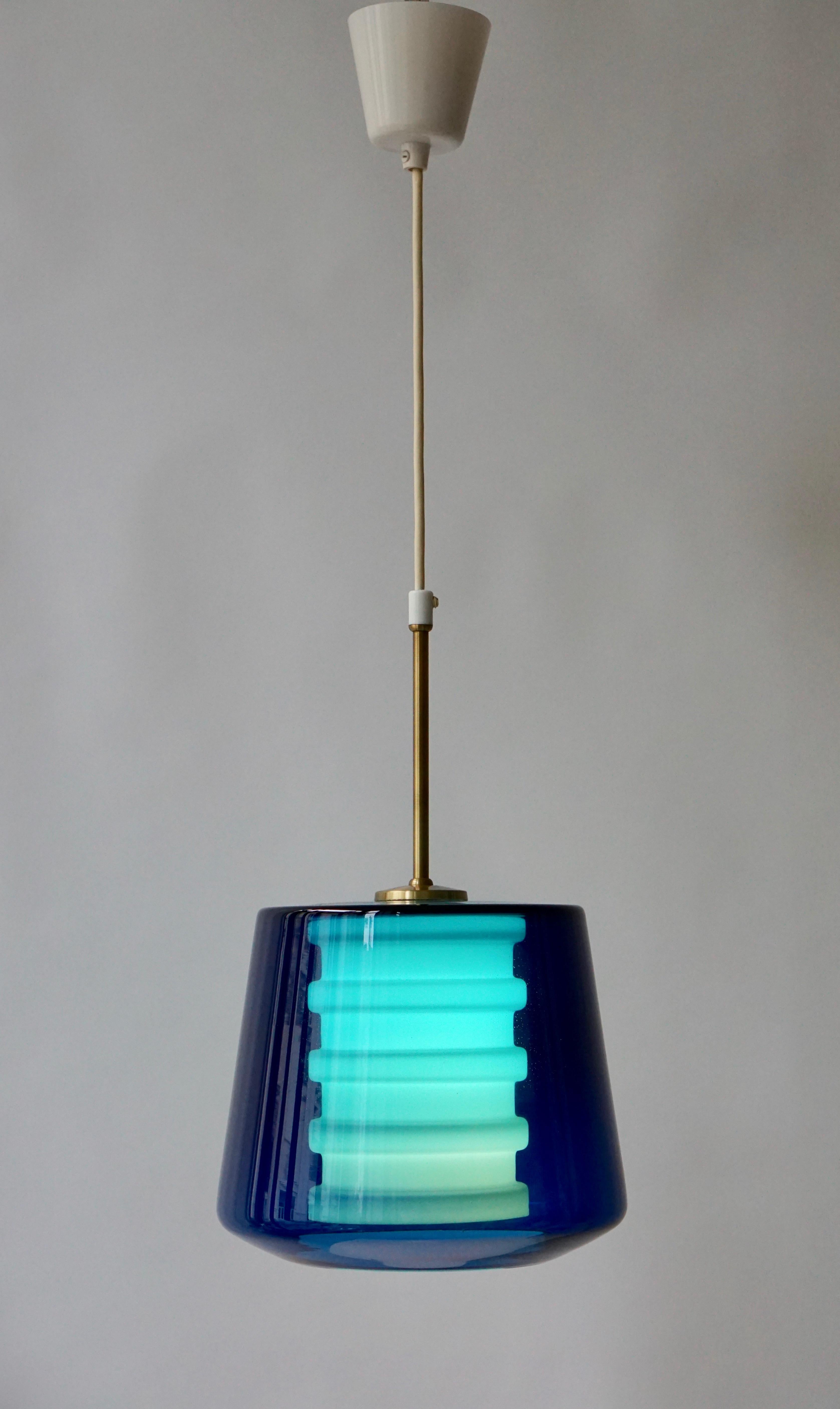 Glass and brass pendant light made in Sweden.
Diameter 25 cm.
Height glass fixture 20 cm.
Height glass fixture with brass rod 40 cm.
Total height 80 cm.