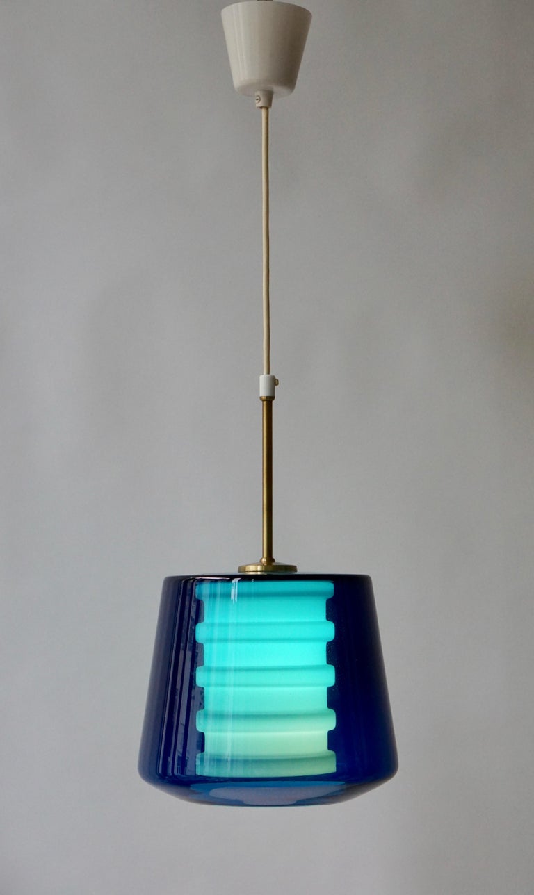 Glass and brass pendant light made in Sweden.
Diameter 25 cm.
Height glass fixture 20 cm.
Height glass fixture with brass rod 40 cm.
Total height 80 cm.