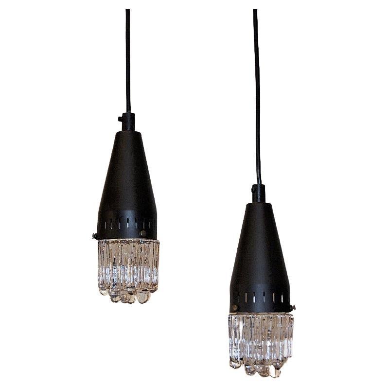 Midcentury pair of glass pendants from the 1960s Scandinavia. The lamps are made of black metal and pressed relieff glass. The lamps have a coneshaped metal top and long black cords to be adjusted to preferred heights.
Suitable both as ceiling -and