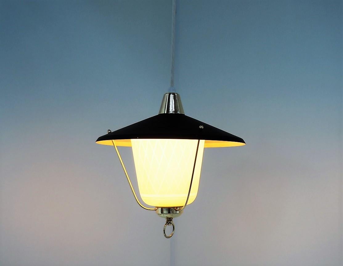 Adorable pendant from the 1940s made in yellow glass, black shade and held together with brass parts. The pendant is Danish vintage design and could be made by Fog & Morup or Lyfa.

The glass shade is very decorative with harlequin check which
