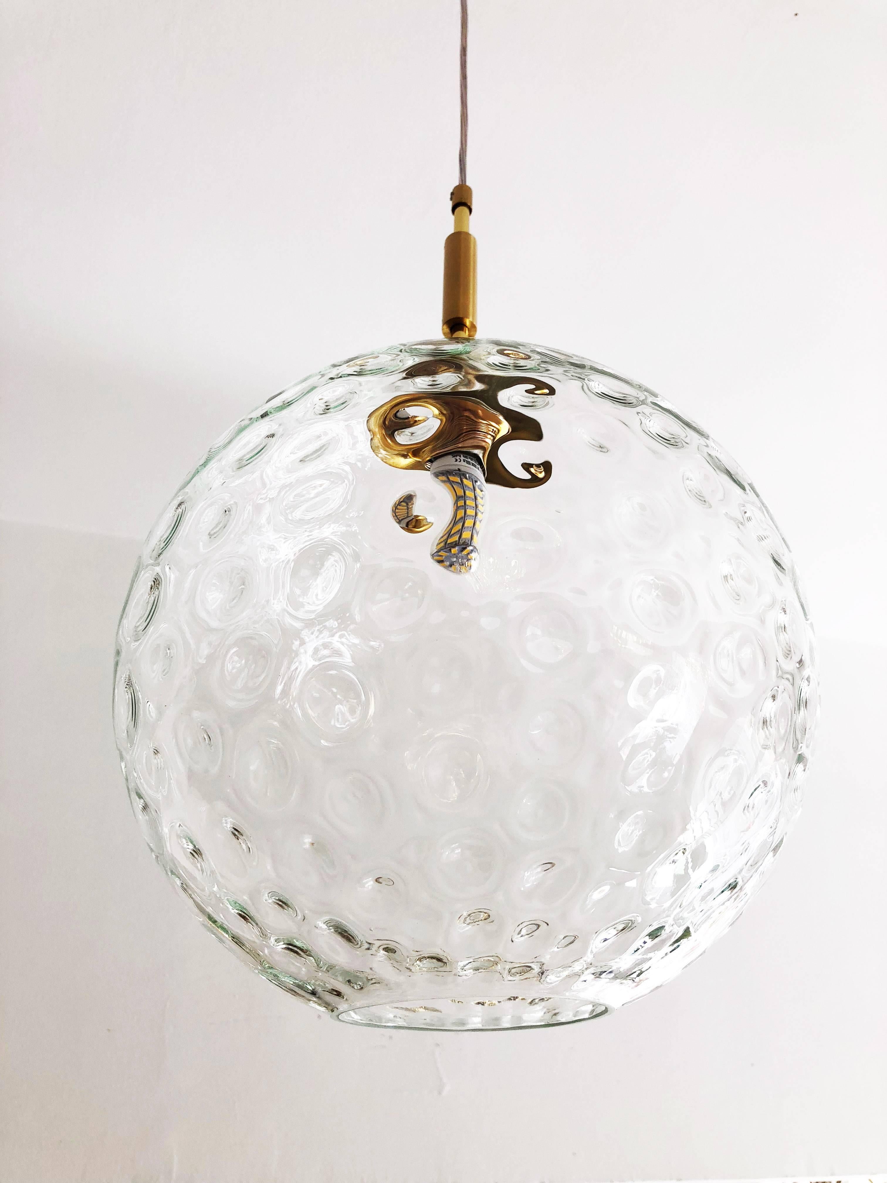 Glass ball with small lenses. Brass hardware fitted with one E27 socket.
Contemporary production.