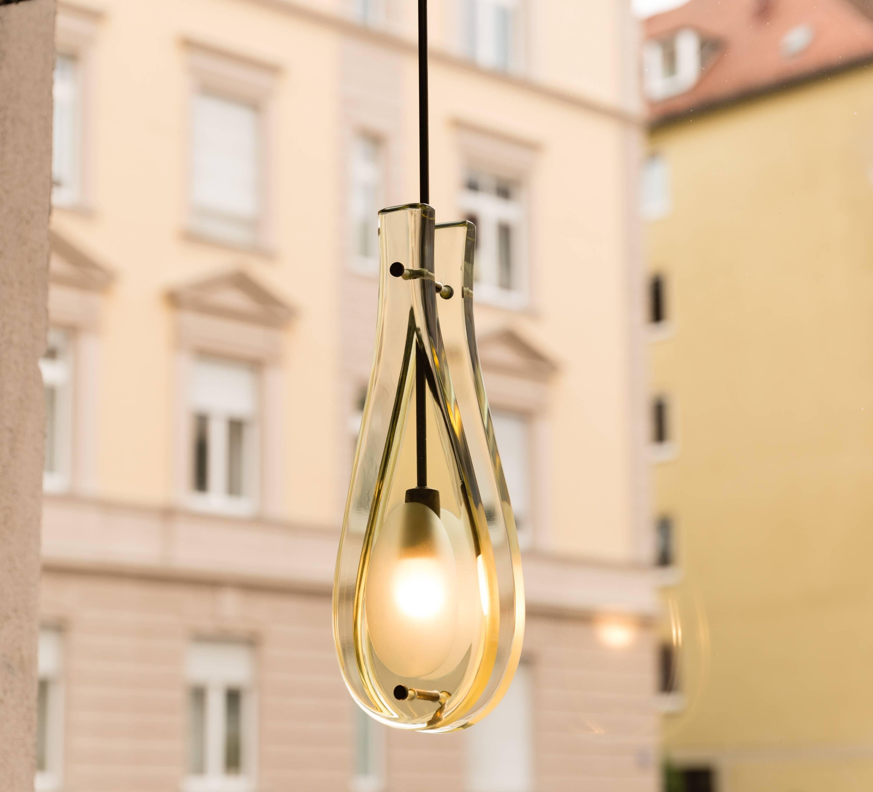 Rare original glass pendant by Max Ingrand for Fontana Arte, Italy, circa 1960. Heavy crystal glass and patinated brass. Very good condition. Height including brass rod and conical canopy 91 cm, depth 10 cm. Two thick light green teardrop-shaped