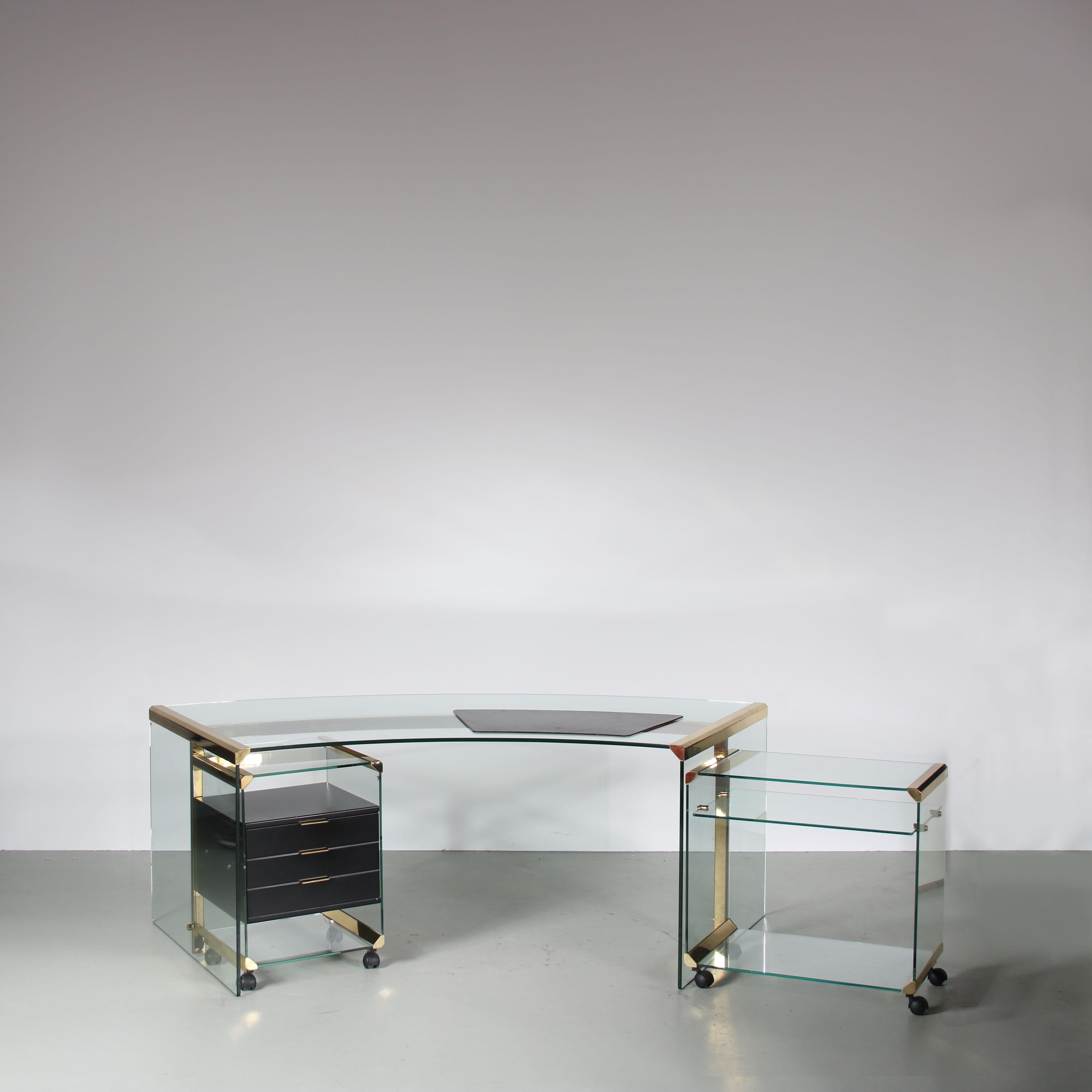 

A stunning piece from the 1970s, this president desk is a true symbol of elegance and sophistication. Designed by Pierangelo Galotti and manufactured by Galotti & Radice in Italy.

The desk is made of beautiful quality clear glass with a brass