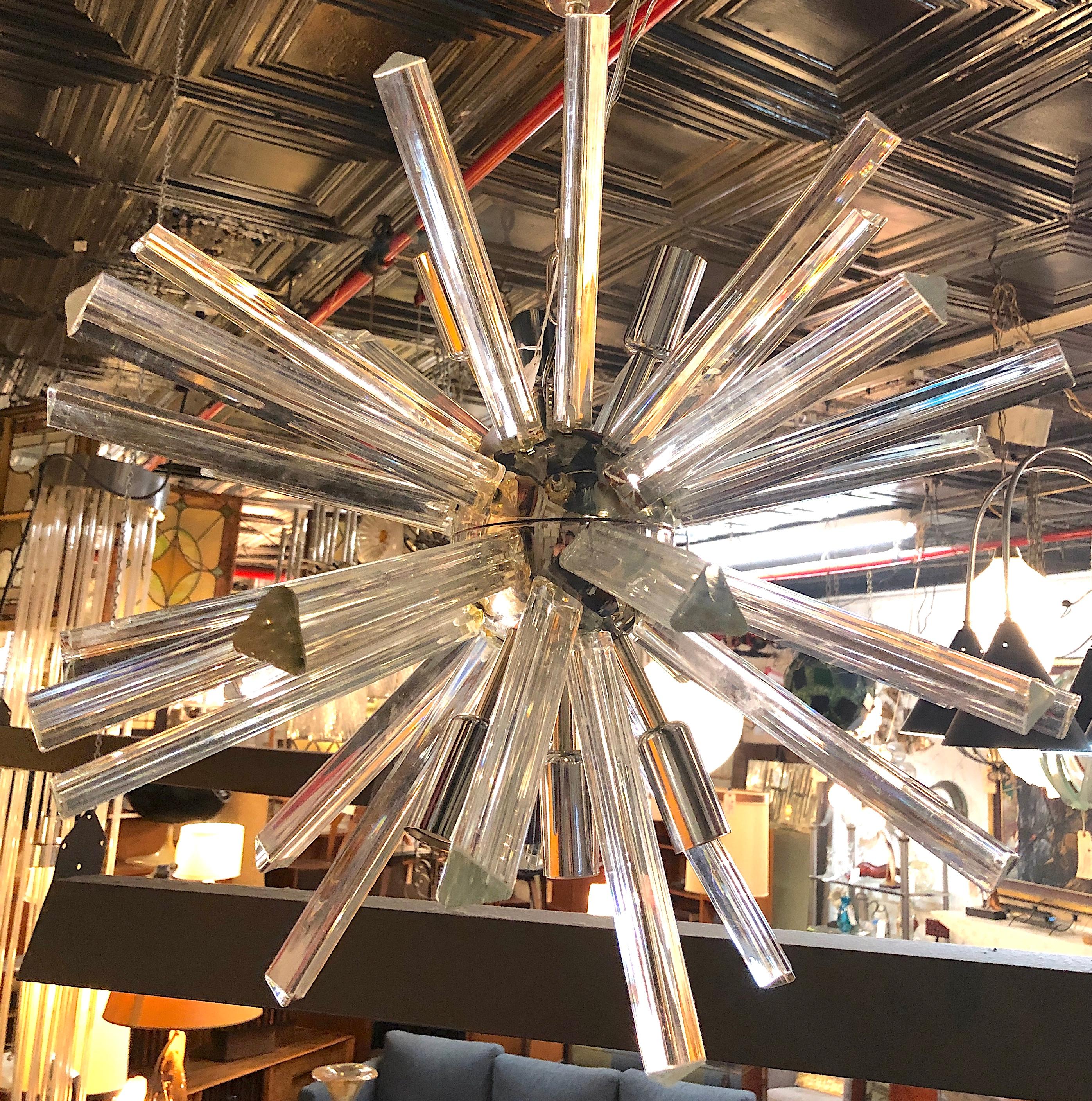 Mid-century modern hanging Sputnik style chandelier with glass prisms. Polished chrome frame and candelabra sockets surrounded by clear triangular glass prisms that help distribute the light.
Please confirm location NY or NJ