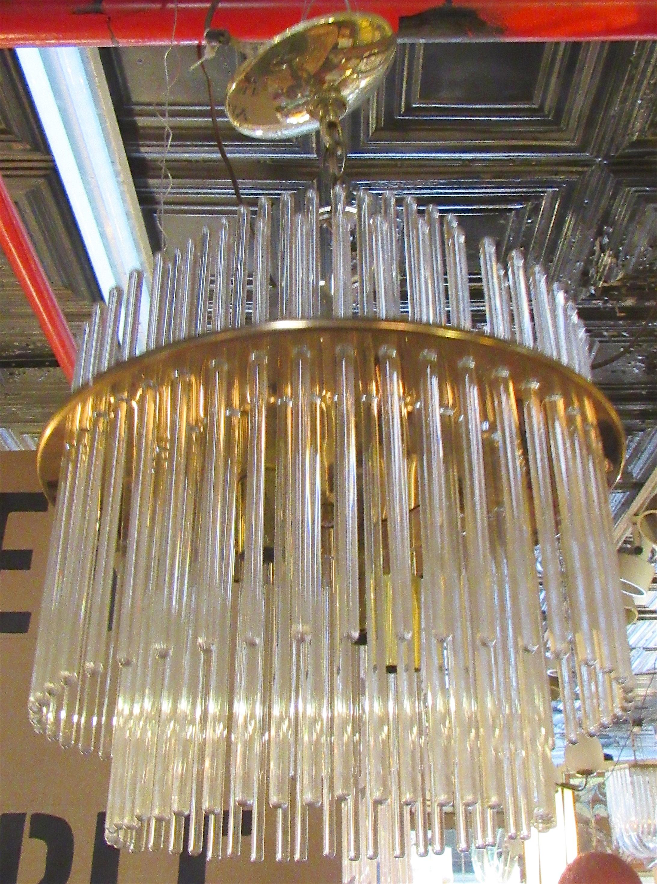 Mid-century modern chandelier by Sciolari Lighting featuring long glass rods set inside a polished brass ring. Two up light, three down light sockets.
Please confirm location NY or NJ