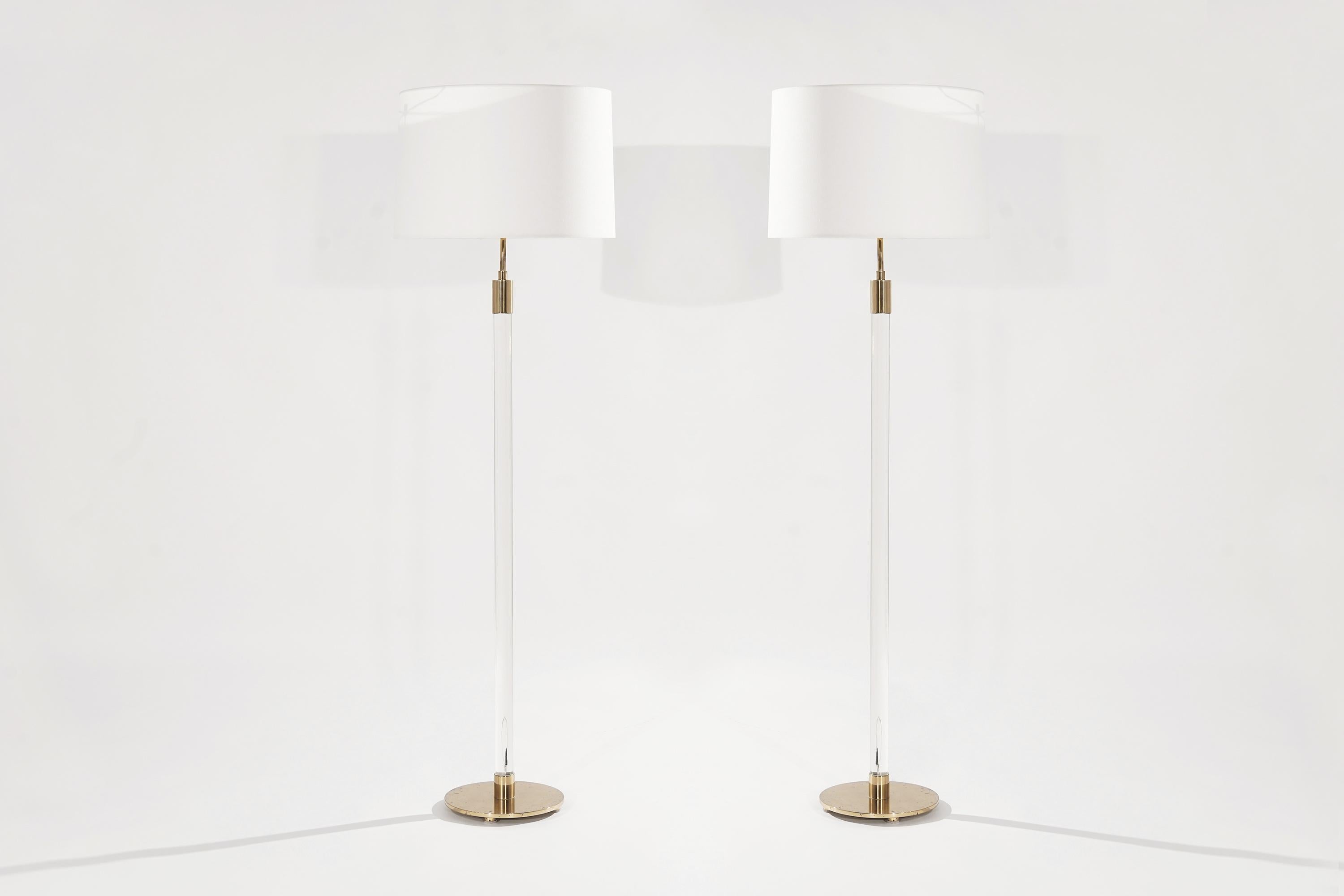 An unusual set of matching glass rod floor lamps on round bronze bases by Hansen Lighting Company. Original wiring in perfect working condition with Dual sockets. The bronze has been hand cleaned, some patina remains—Hansen's signature underneath