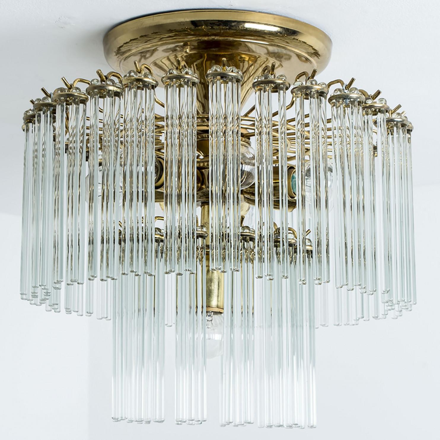 An Italian Mid-Century Modern glass rod and brass Gaetano Sciolari flush mount for Lightolier, circa 1960s-1970s. Illuminates beautifully. With 48 pierced round form clusters of light catching optical quality glass rods (7.1 inch) sitting on a brass