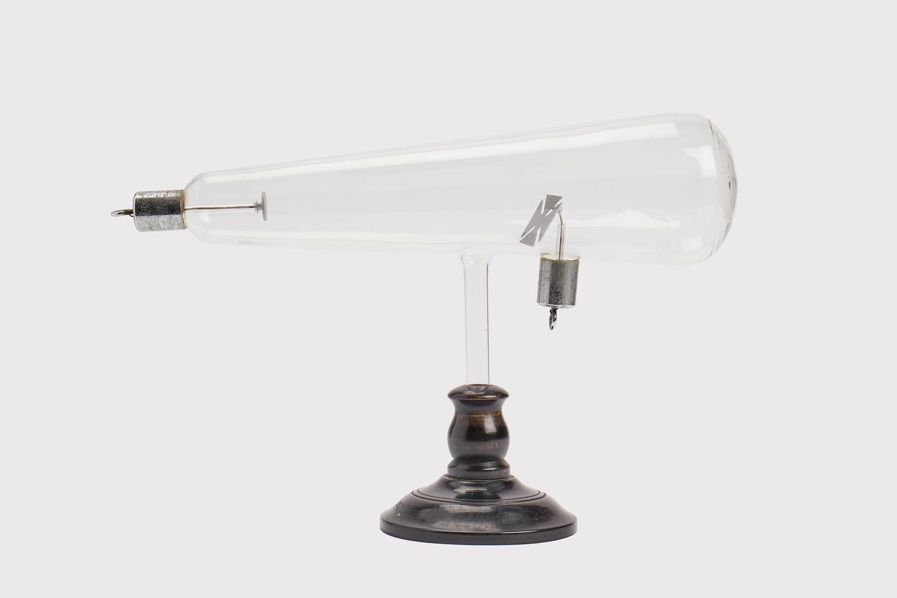 Blown glass scientific instrument. An example of the Crookes tube with Maltese Cross, in chromed metal, a precursor to the cathode ray tube. It was used to demonstrate the rectilinear movement of rays, so that the intervening elements generated