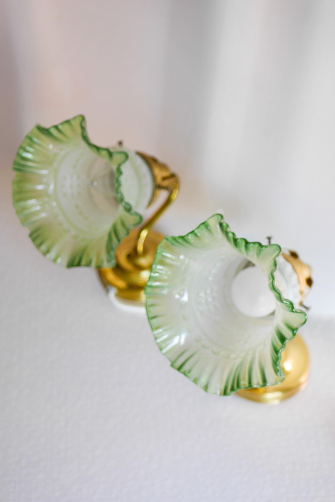 A pair of really beautiful and elegant mid-century modern Scandinavian vintage glass sconces/ wall lighing, which have a fantastic frosted class cone with a pale green trimming mounted on to a brass base metal fitting. The lamps are from to Abu