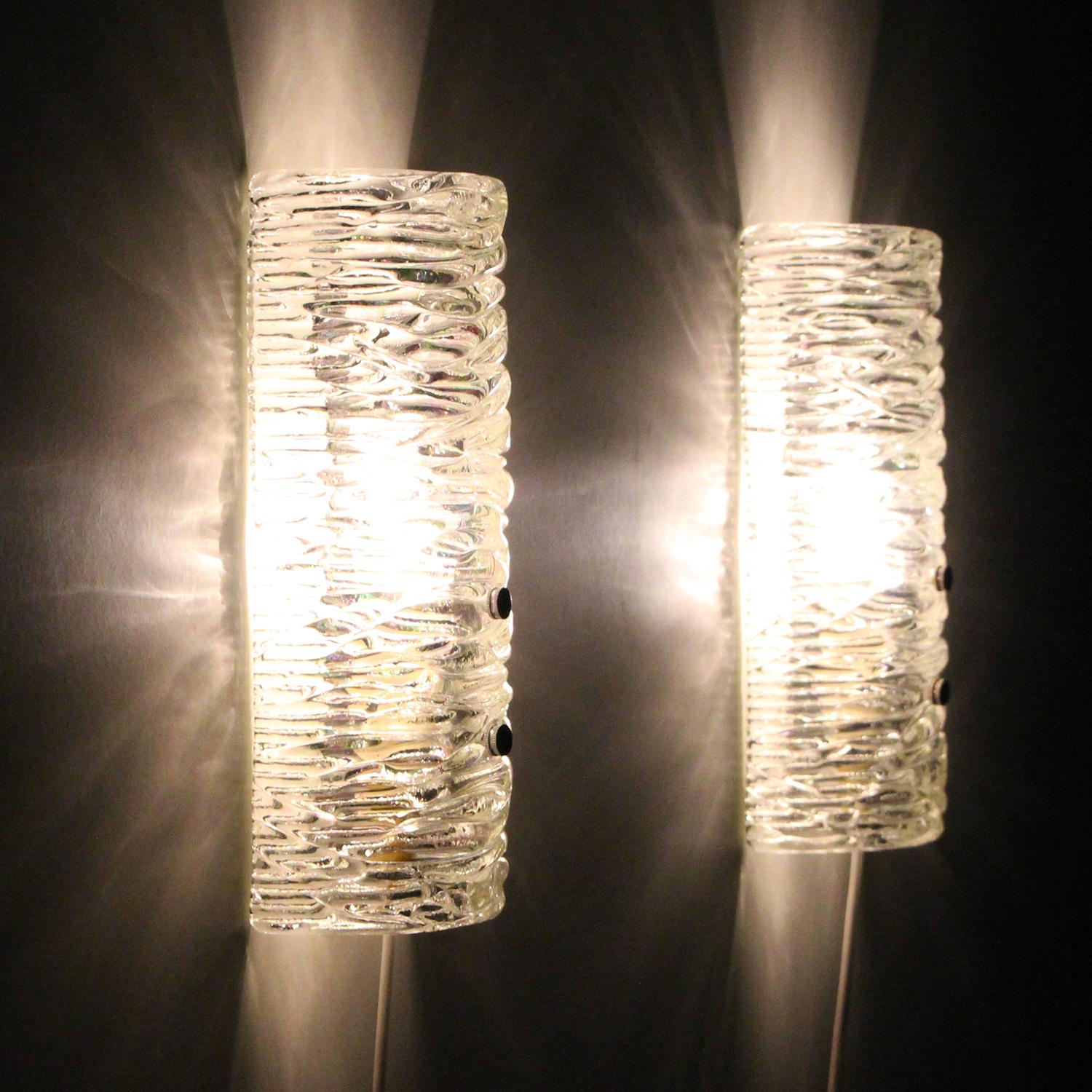 Glass sconces (pair) - pair of clear glass wall lights by unknown producer, 1960s. Beautiful Scandinavian glass wall lamps in excellent vintage condition.

Each of these beautiful sconces are comprised of a clear crystal glass piece, curved to