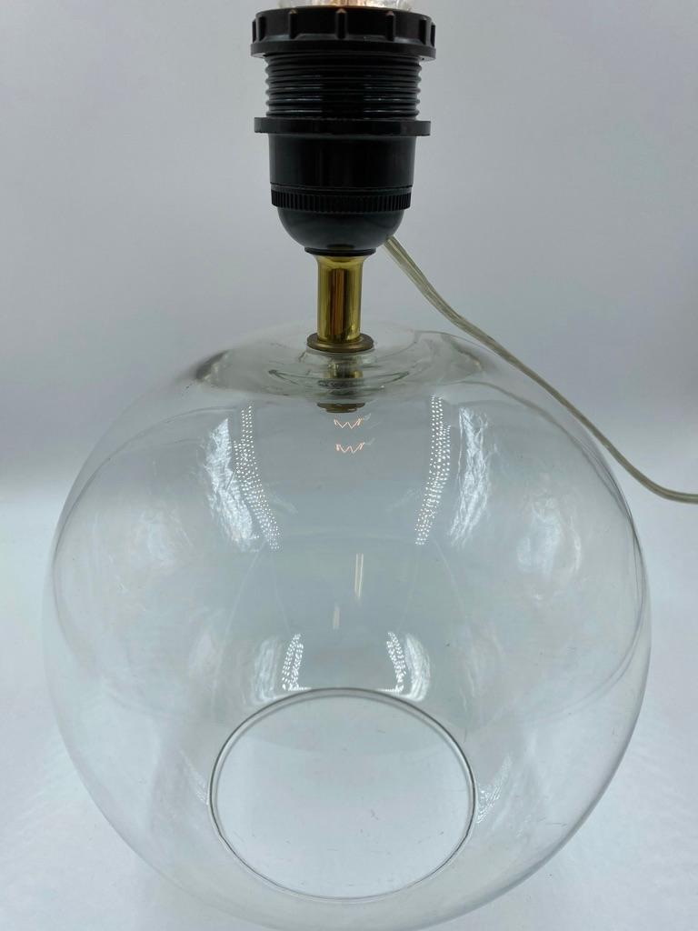 Hollywood recency style glass sphere table lamp base with brass accents. This beautiful table lamp is from the 1980s and would fit in any style of interieur.
     